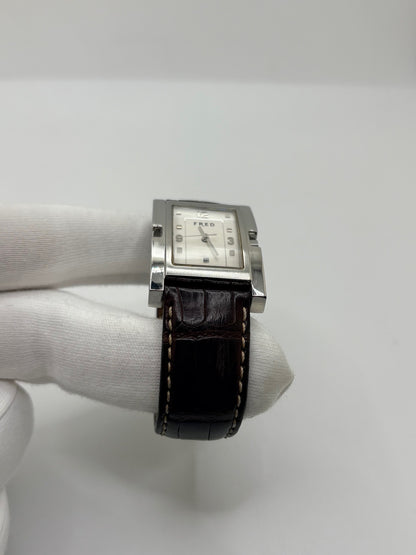 Montre Fred Tank R09-100 en excellent état, dotée d’un mouvement quartz et d’un boîtier en acier de 33 × 27 mm. Cette montre élégante présente un cadran blanc avec chiffres arabes, protégé par un verre saphir. Elle est accompagnée d’un bracelet en cuir brun avec boucle en acier. Modèle homme ou unisexe, cette Fred Tank R09-100 séduit par son design classique et intemporel, idéal pour compléter une tenue élégante au quotidien.
