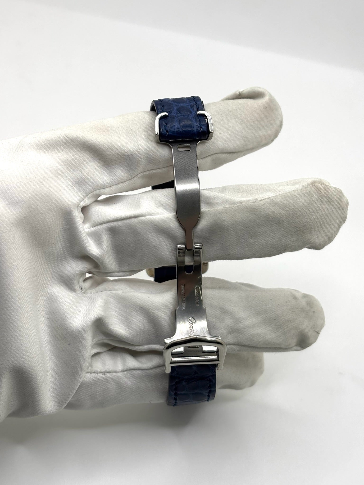 Montre Cartier Tank Must référence 2416 en argent avec cadran blanc à chiffres arabes et mouvement quartz. Ce modèle iconique présente un boîtier rectangulaire de 22 x 30 mm, une lunette en argent et un bracelet en cuir bleu avec boucle ardillon en acier. Cartier Tank Must d'occasion en très bon état, avec de légères traces d'usure. Montre homme ou unisexe élégante et intemporelle, idéale pour les amateurs d'horlogerie et de montres de luxe vintage.
