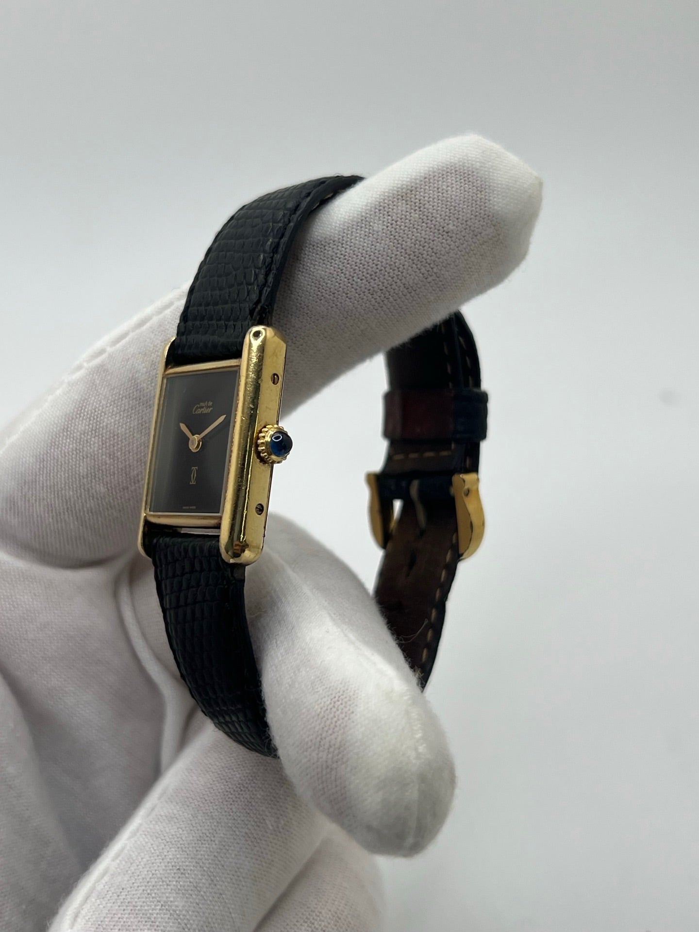 Montre Cartier Tank Must Vermeil référence 5057001 pour femme, boîtier en argent 20 x 28 mm, cadran noir sans chiffres et bracelet en cuir de lézard noir. Modèle à mouvement quartz, en bon état avec traces d’usure légères. Montre élégante au style intemporel, idéale pour un look sophistiqué et raffiné. Parfaite pour les amateurs de pièces vintage.
