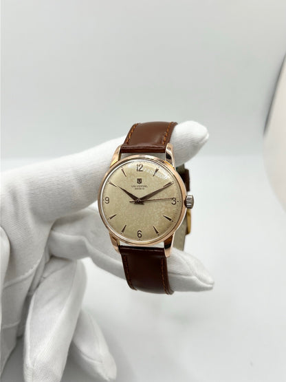 Montre Universal Genève 412501/1 vintage en très bon état, datant approximativement de 1950, avec un mouvement à remontage manuel. Son boîtier de 34,5 mm plaqué or est associé à un cadran blanc à chiffres arabes et un verre Plexiglas. Cette montre Universal Genève possède un bracelet en cuir brun avec boucle ardillon en acier. Un modèle homme ou unisexe au style classique et élégant, idéal pour les amateurs d’horlogerie vintage.