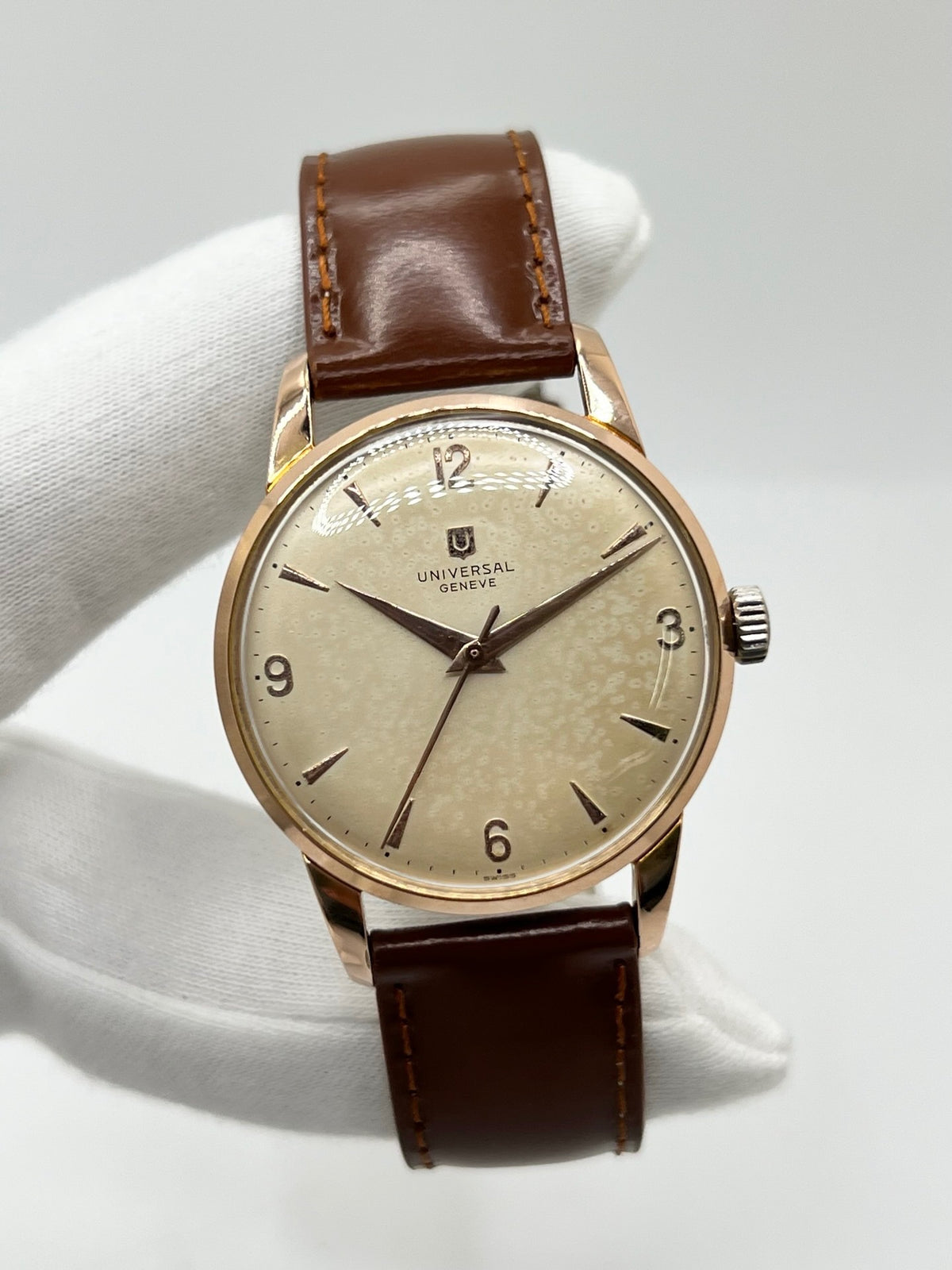 Montre Universal Genève 412501/1 vintage en très bon état, datant approximativement de 1950, avec un mouvement à remontage manuel. Son boîtier de 34,5 mm plaqué or est associé à un cadran blanc à chiffres arabes et un verre Plexiglas. Cette montre Universal Genève possède un bracelet en cuir brun avec boucle ardillon en acier. Un modèle homme ou unisexe au style classique et élégant, idéal pour les amateurs d’horlogerie vintage.