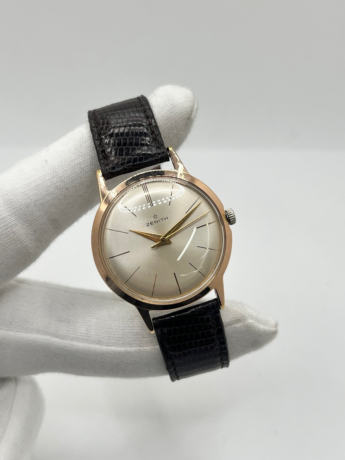 Montre Zenith Stellina vintage à remontage manuel, dotée d’un boîtier plaqué or et d’un élégant cadran champagne. Cette montre Zenith se distingue par son style classique et intemporel, emblématique de l’horlogerie traditionnelle. Elle est équipée d’un bracelet brun en cuir de lézard, complété par une boucle ardillon en acier. Avec son esthétique raffinée et son allure rétro, la Zenith Stellina séduit les amateurs de montres anciennes et de pièces horlogères au charme authentique.