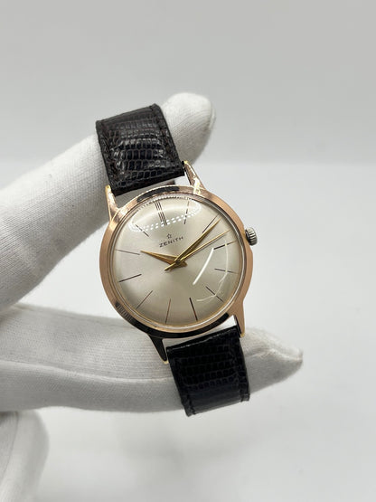 Montre Zenith Stellina vintage à remontage manuel, dotée d’un boîtier plaqué or et d’un élégant cadran champagne. Cette montre Zenith se distingue par son style classique et intemporel, emblématique de l’horlogerie traditionnelle. Elle est équipée d’un bracelet brun en cuir de lézard, complété par une boucle ardillon en acier. Avec son esthétique raffinée et son allure rétro, la Zenith Stellina séduit les amateurs de montres anciennes et de pièces horlogères au charme authentique.