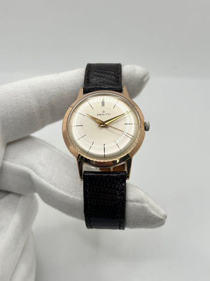Montre Zenith Stellina vintage à remontage manuel, dotée d’un boîtier plaqué or et d’un élégant cadran champagne. Cette montre Zenith se distingue par son style classique et intemporel, emblématique de l’horlogerie traditionnelle. Elle est équipée d’un bracelet brun en cuir de lézard, complété par une boucle ardillon en acier. Avec son esthétique raffinée et son allure rétro, la Zenith Stellina séduit les amateurs de montres anciennes et de pièces horlogères au charme authentique.