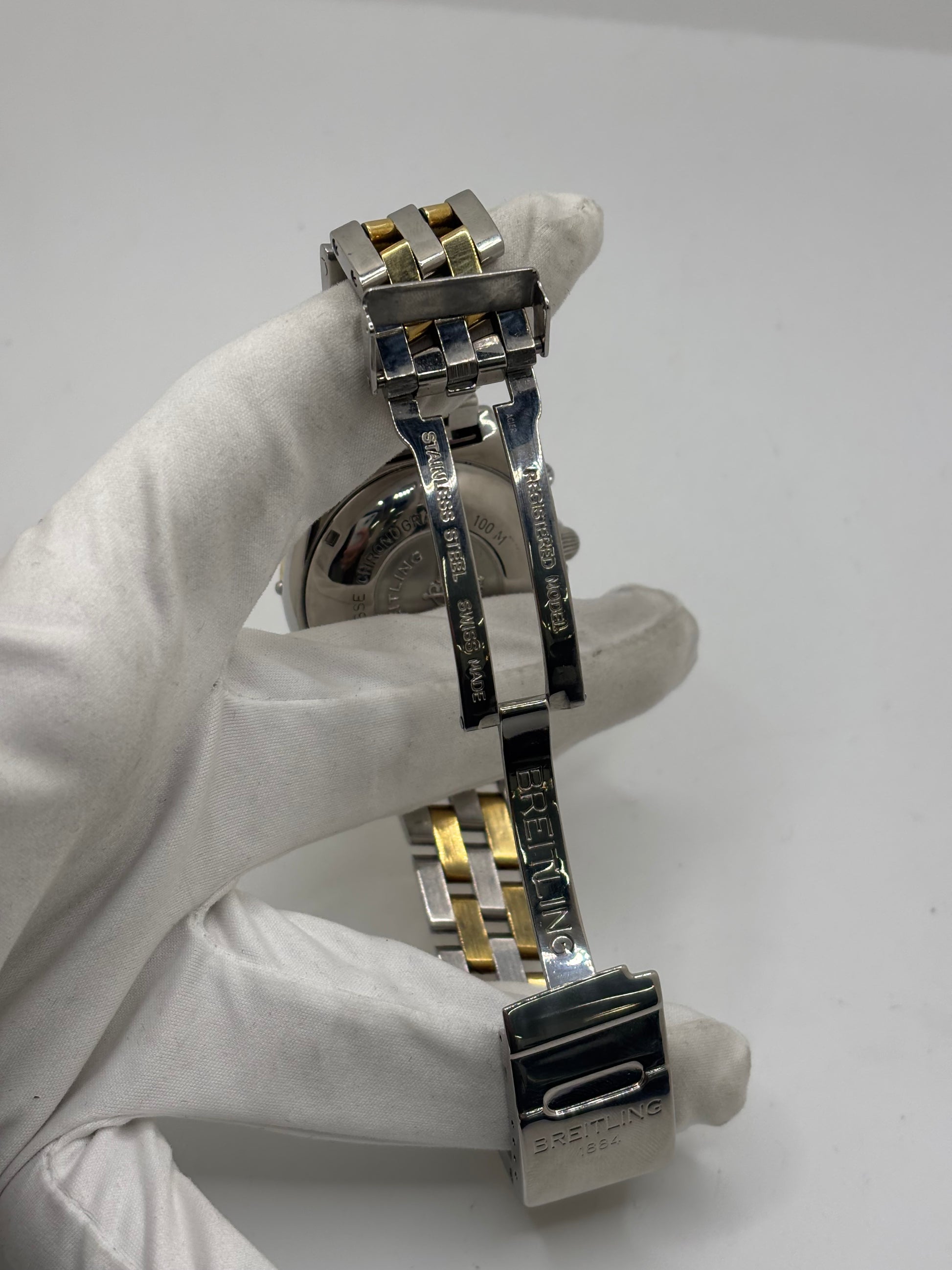 Montre Breitling Chronomat B13050.1 en or et acier avec boîtier de 39 mm, cadran blanc à chiffres arabes, verre saphir et mouvement automatique Breitling 13 basé sur l'ETA Valjoux 7750. Ce chronographe est équipé d'un bracelet en or et acier avec boucle déployante d'origine. Révisée, en excellent état et garantie 1 an, cette montre de luxe suisse allie élégance intemporelle, précision horlogère et finitions haut de gamme.