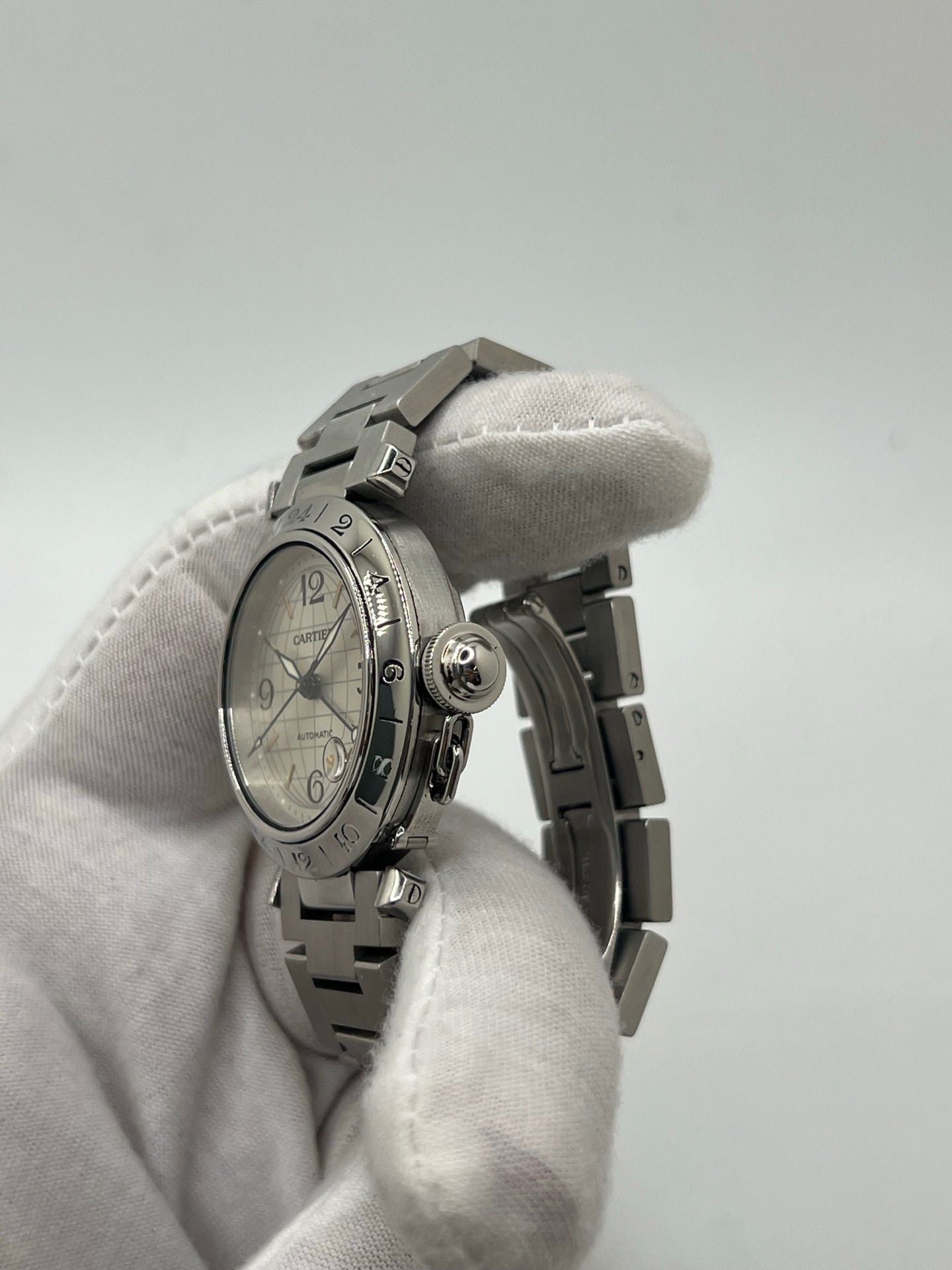 Montre Cartier Pasha C GMT réf. 2377 en acier, dotée d’un mouvement automatique calibre 048. Son boîtier de 35 mm abrite un cadran argenté à chiffres arabes, protégé par un verre saphir. Étanche jusqu’à 10 ATM, cette montre élégante et fonctionnelle est équipée d’un bracelet en acier et d’une boucle déployante double plis.