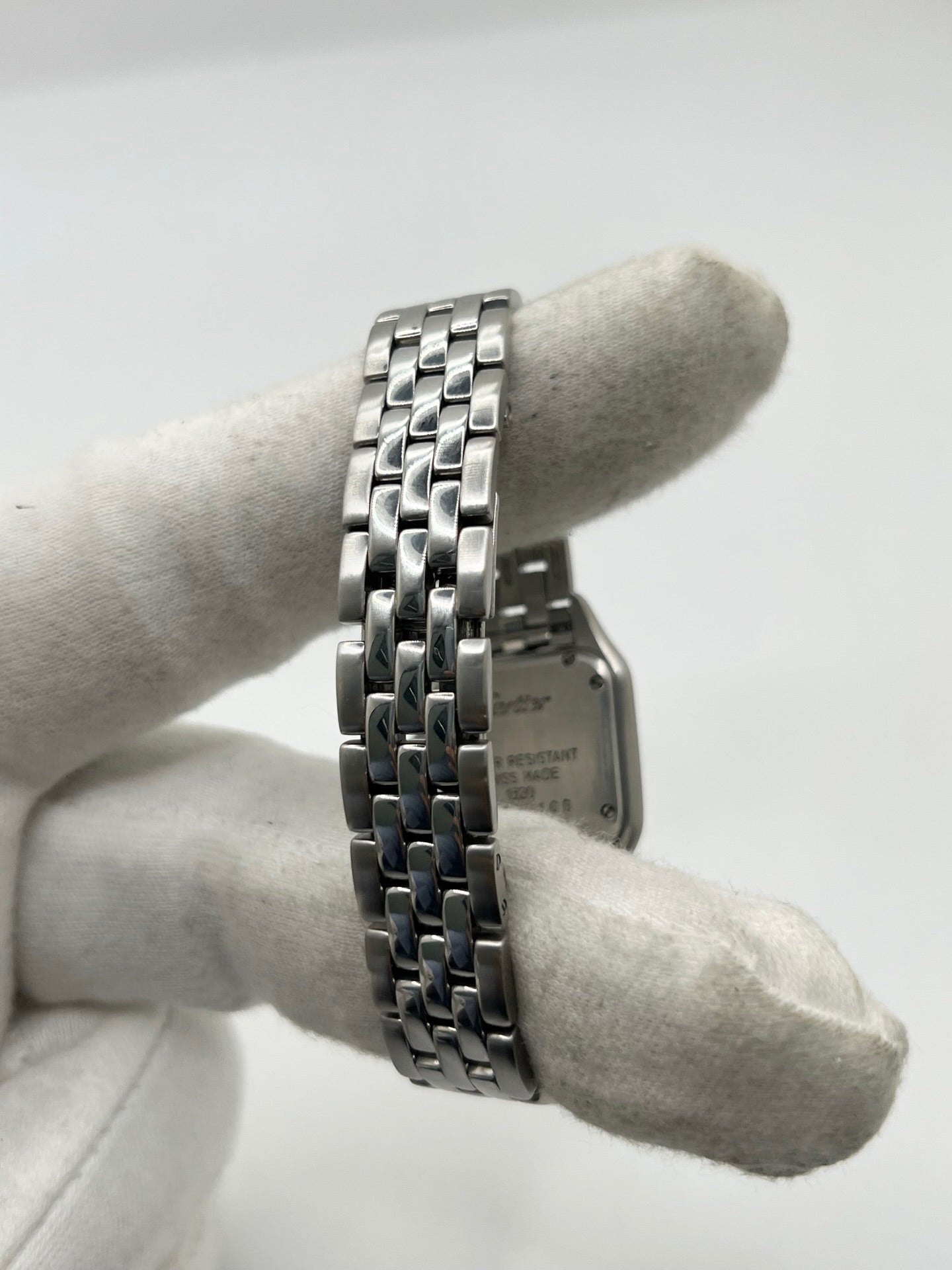 Cartier Panthère référence 1320 en acier avec boîtier de 22 mm, cadran blanc à chiffres romains et mouvement à quartz. Cette montre femme est équipée d'un bracelet en acier avec boucle déployante double pli et d'un verre saphir. Modèle d'occasion en très bon état, révisé par le fabricant en 2026, livré avec son coffret et ses papiers d'origine.