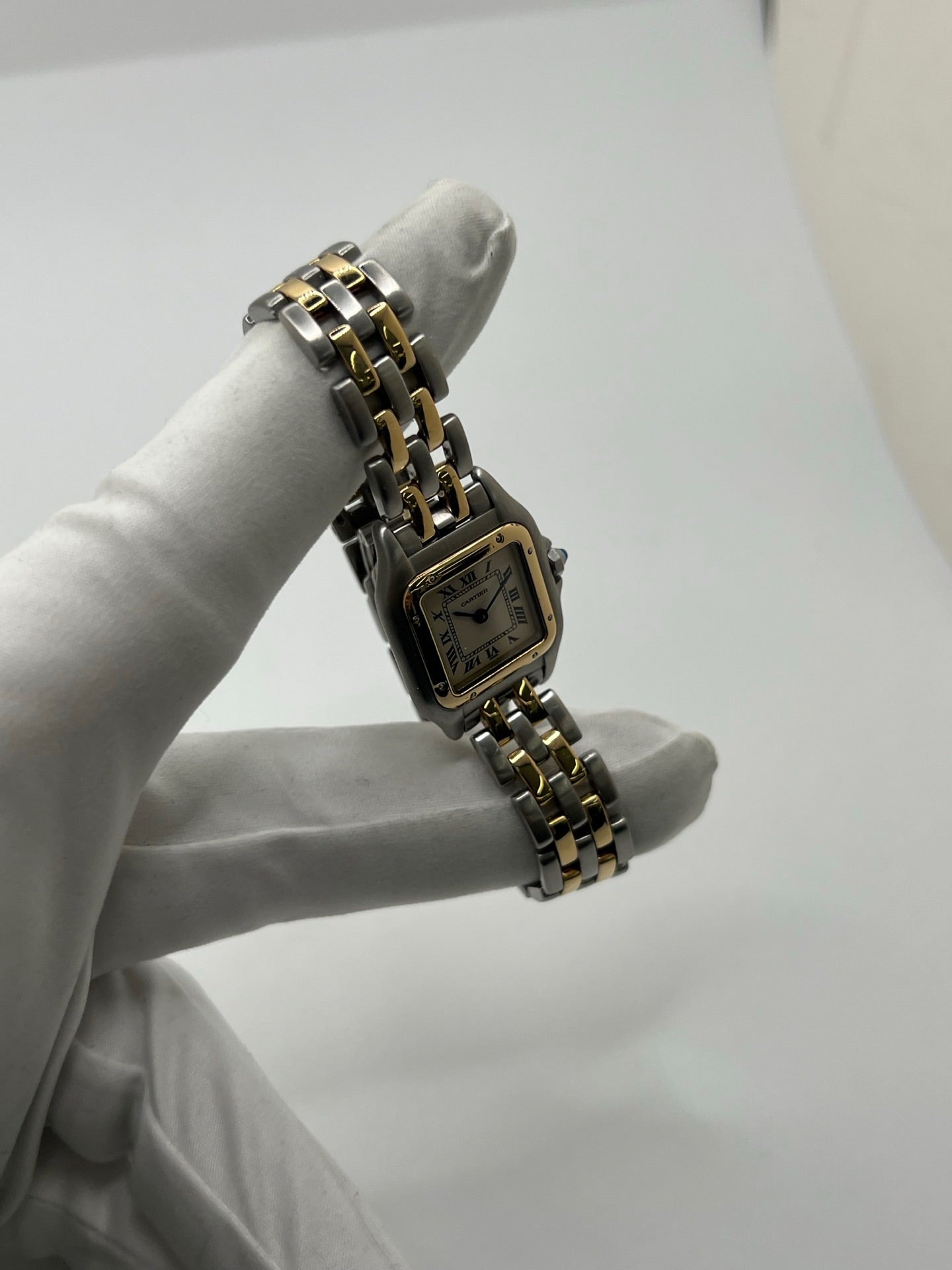 Montre Cartier Panthère 166921 pour femme en or et acier, équipée d’un mouvement quartz suisse. Ce modèle iconique présente un boîtier de 22 x 21 mm, une lunette en or jaune, un cadran blanc à chiffres romains et un verre saphir. Son bracelet en or et acier avec boucle double plis complète son élégance intemporelle. Montre de luxe d’occasion en très bon état, révisée, avec coffret d’origine, idéale pour les amateurs de montres Cartier Panthère femme.