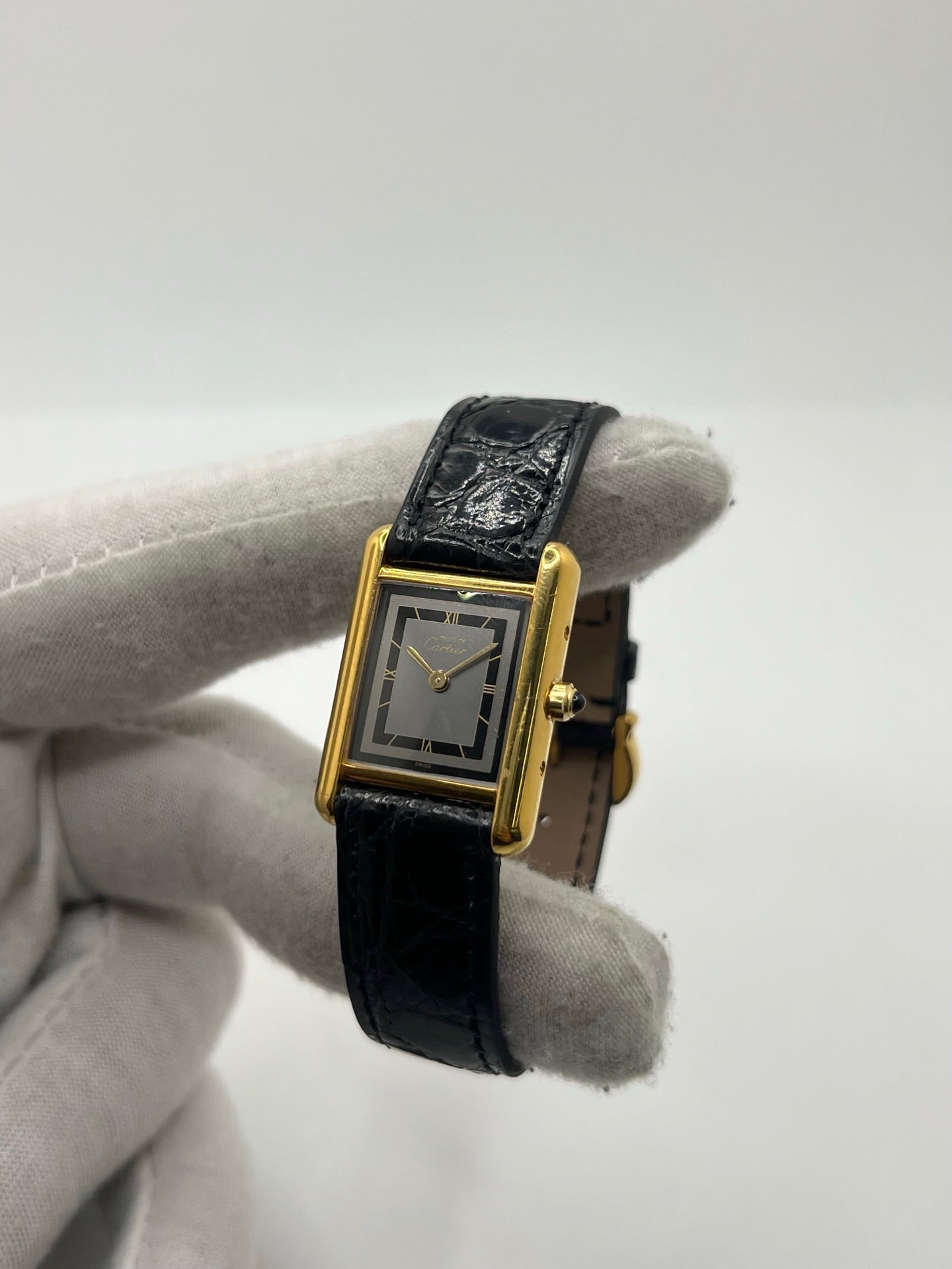 Montre Cartier Tank Vermeil 3 66001 pour femme, équipée d’un mouvement quartz et d’un boîtier en argent de 20 x 27 mm. Ce modèle d’occasion en très bon état présente un cadran or à chiffres romains, un verre minéral et un bracelet en cuir de crocodile noir avec boucle en acier. Élégante et intemporelle, la Cartier Tank Vermeil 3 66001 séduit par son design classique, idéale pour les passionnées de montres de luxe raffinées.