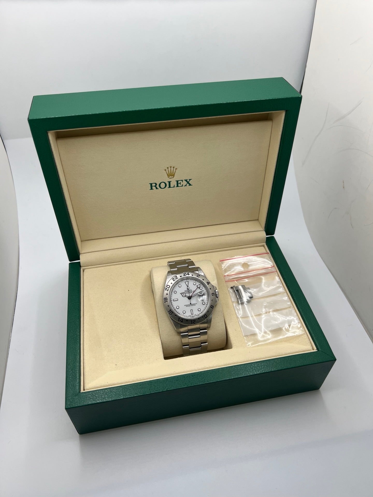 Montre Rolex Explorer II 16570 pour homme ou unisexe en acier, équipée d’un mouvement automatique calibre 3185 avec réserve de marche de 50 heures. Ce modèle emblématique de 1989 présente un boîtier de 40 mm, une lunette en acier, un cadran blanc sans chiffres, un verre saphir et un bracelet en acier avec boucle pliante. Fonction date et GMT. Montre de luxe d’occasion en bon état, révisée en interne, avec coffret d’origine, idéale pour les amateurs de Rolex Explorer II vintage.