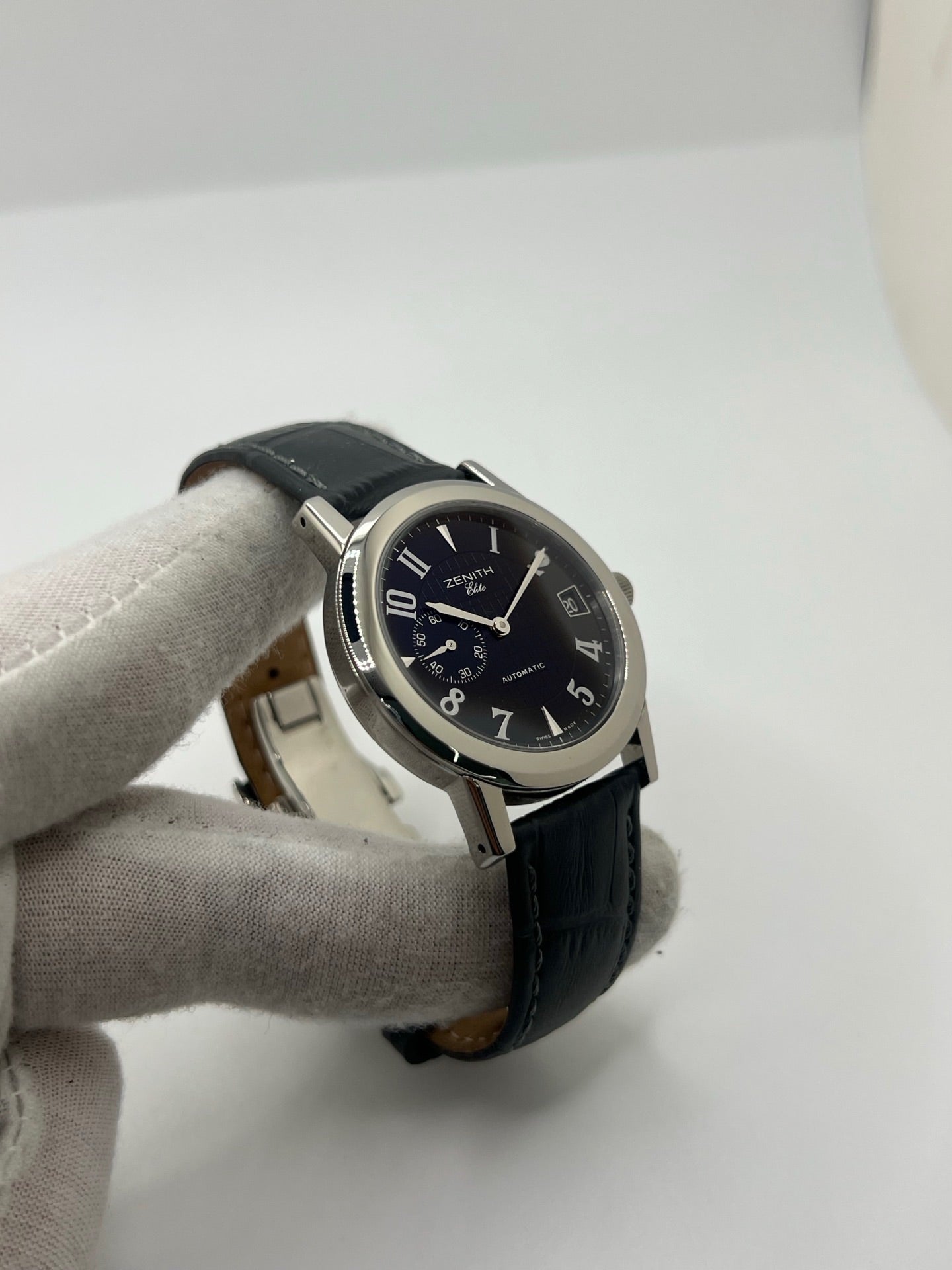 Montre Zenith Port Royal automatique en acier, modèle homme ou unisexe de 2007, équipée d’un boîtier de 37 mm et d’un élégant cadran noir à chiffres arabes. Cette montre d’occasion en très bon état dispose d’un verre saphir, d’une fonction date et d’une petite seconde. Son bracelet en cuir noir avec boucle ardillon souligne son style raffiné. Une montre Zenith Port Royal de luxe au design intemporel, idéale pour les passionnés d’horlogerie et les amateurs de pièces élégantes.