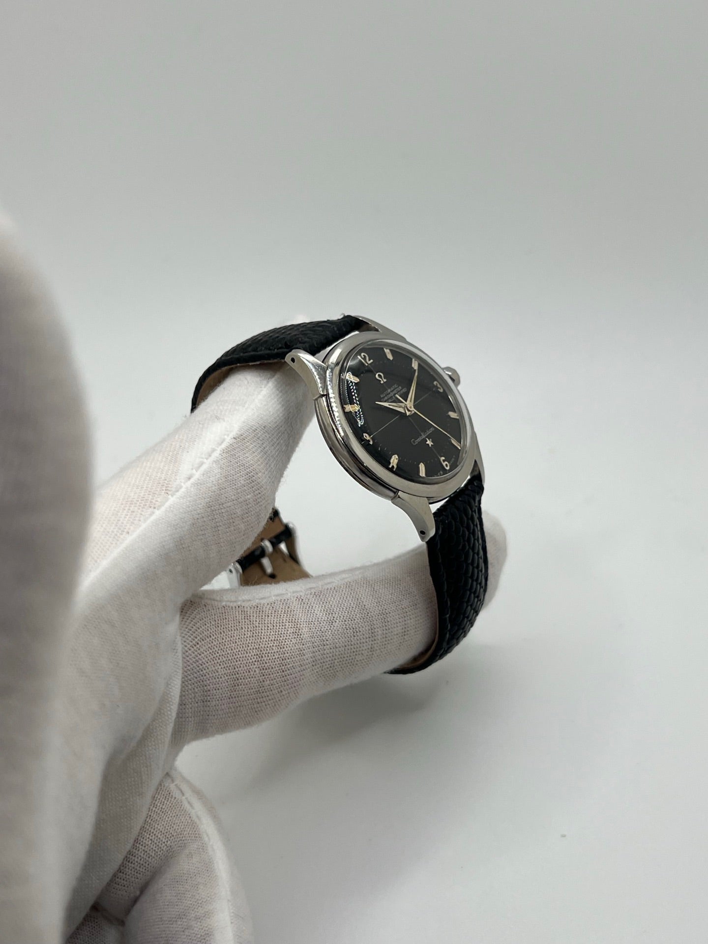 Montre automatique vintage en acier avec boîtier rond de 35 mm, cadran noir à chiffres arabes et verre plexiglas. Modèle chronomètre des années 1950 équipé d’un calibre automatique 505 avec réserve de marche de 46 heures. Bracelet en cuir noir avec boucle ardillon en acier. Montre d’occasion présentant des traces d’usure visibles, révisée récemment, sans coffret ni papiers d’origine.