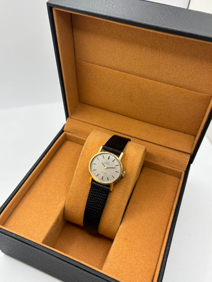 Montre Omega De Ville vintage référence 511.0508 pour femme, datant de 1967, avec boîtier en acier de 24 mm et cadran gris à index bâtons. Cette montre à remontage manuel est équipée du calibre Omega 625 à 17 rubis et est montée sur un bracelet en cuir noir avec boucle ardillon en acier. Révisée et en très bon état, elle présente de légères traces d'usure conformes à son âge. Une montre de collection au design élégant, idéale pour les amateurs d'horlogerie vintage.