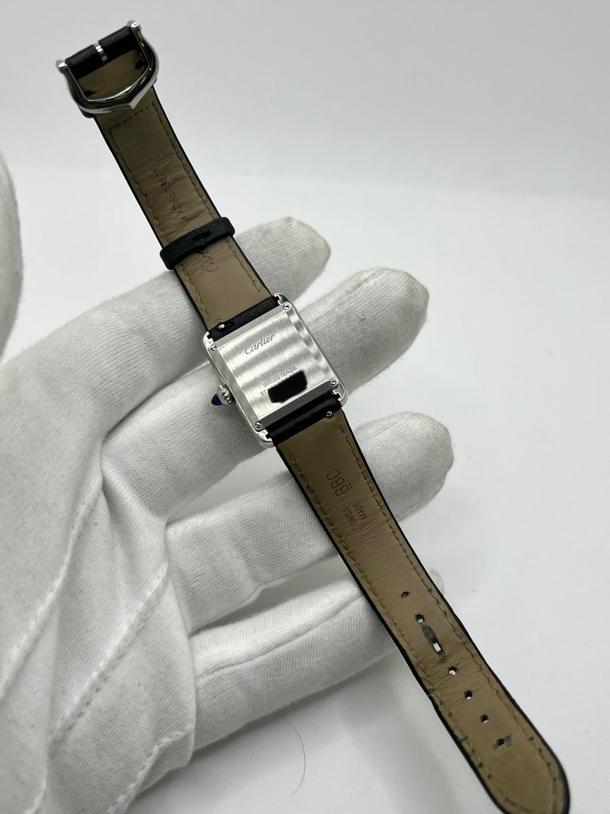Montre Cartier Tank Must PM WSTA0042 pour femme, modèle élégant de la collection Tank datant de 2021. Cette montre de luxe se distingue par son boîtier rectangulaire en acier de 22 x 29 mm, son cadran argenté, son verre saphir et son bracelet en cuir noir. Équipée d’un mouvement à quartz, la Cartier Tank Must PM allie sobriété et élégance intemporelle. Proposée d’occasion en très bon état, elle est vendue avec son coffret d’origine et a bénéficié d’une révision interne le 19 octobre 2026.