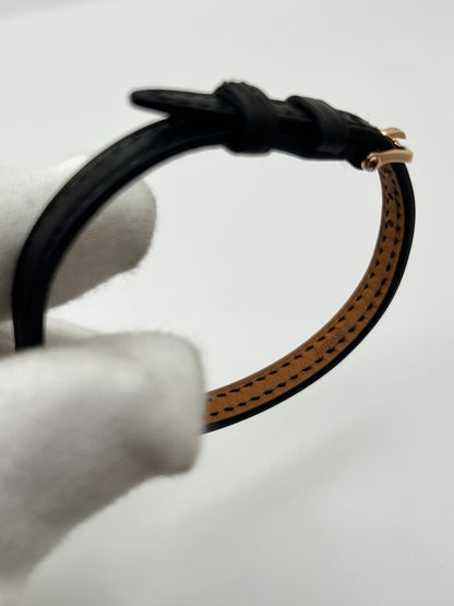Montre Hermès Faubourg FG4.171 pour femme, dotée d’un élégant boîtier en or rose de 15,5 mm et d’un mouvement quartz. Elle se distingue par son cadran noir sans chiffres, protégé par un verre saphir, et son bracelet en cuir noir avec boucle ardillon en or rose. Cette montre de luxe Hermès associe raffinement, élégance et discrétion. Modèle d’occasion en très bon état, révisé en interne en octobre 2026 et livré avec son coffret d’origine.