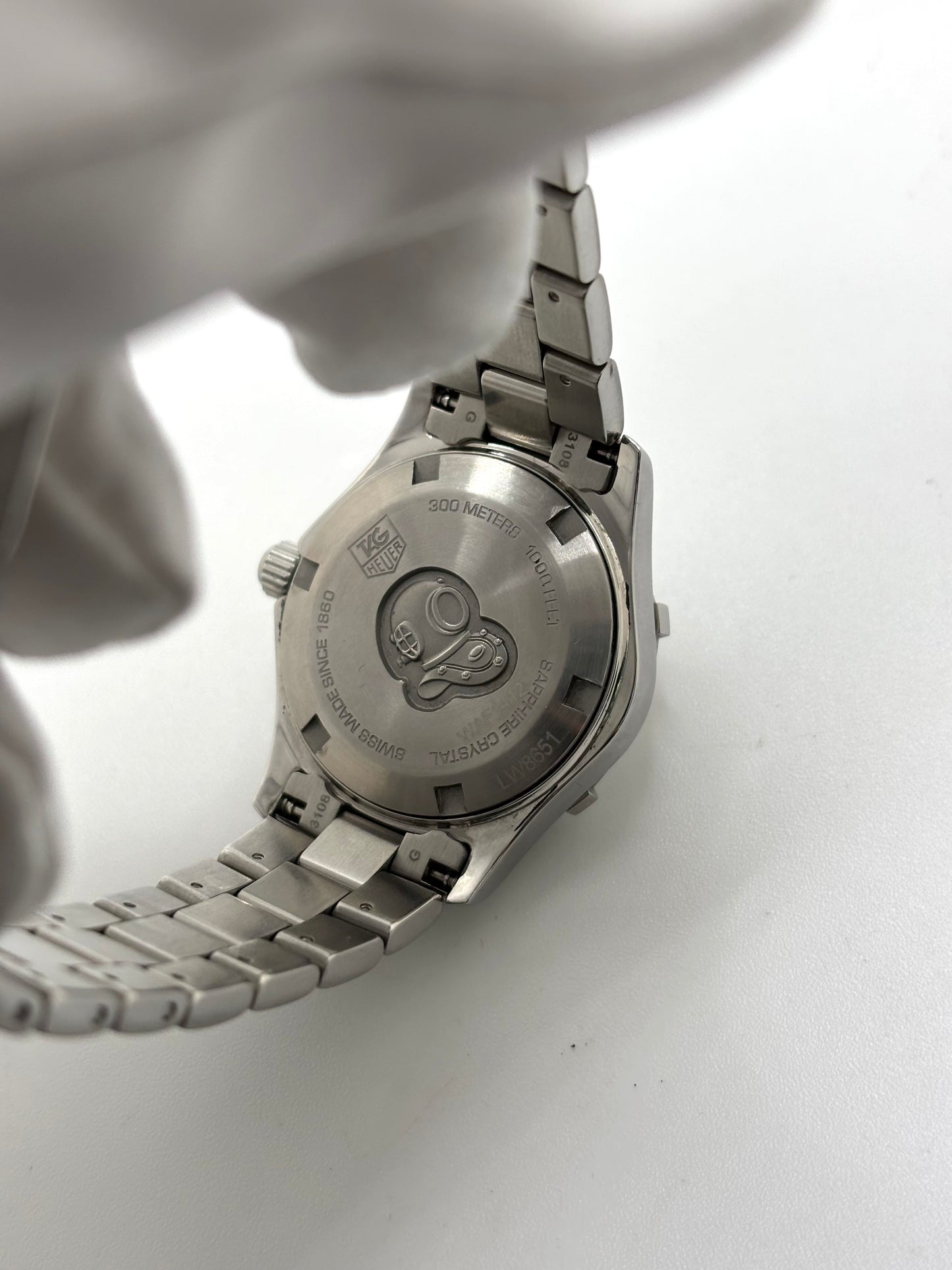 Montre femme TAG Heuer Aquaracer Lady référence WAF1412 en acier avec boîtier 27 mm et bracelet acier. Cadran argent avec chiffres arabes, mouvement quartz précis et étanchéité 30 ATM. Montre de luxe sportive et élégante en très bon état, révisée en 2026, idéale pour un usage quotidien ou une tenue habillée. Détail du boîtier acier poli, montre horlogère suisse féminine, intemporelle et raffinée.