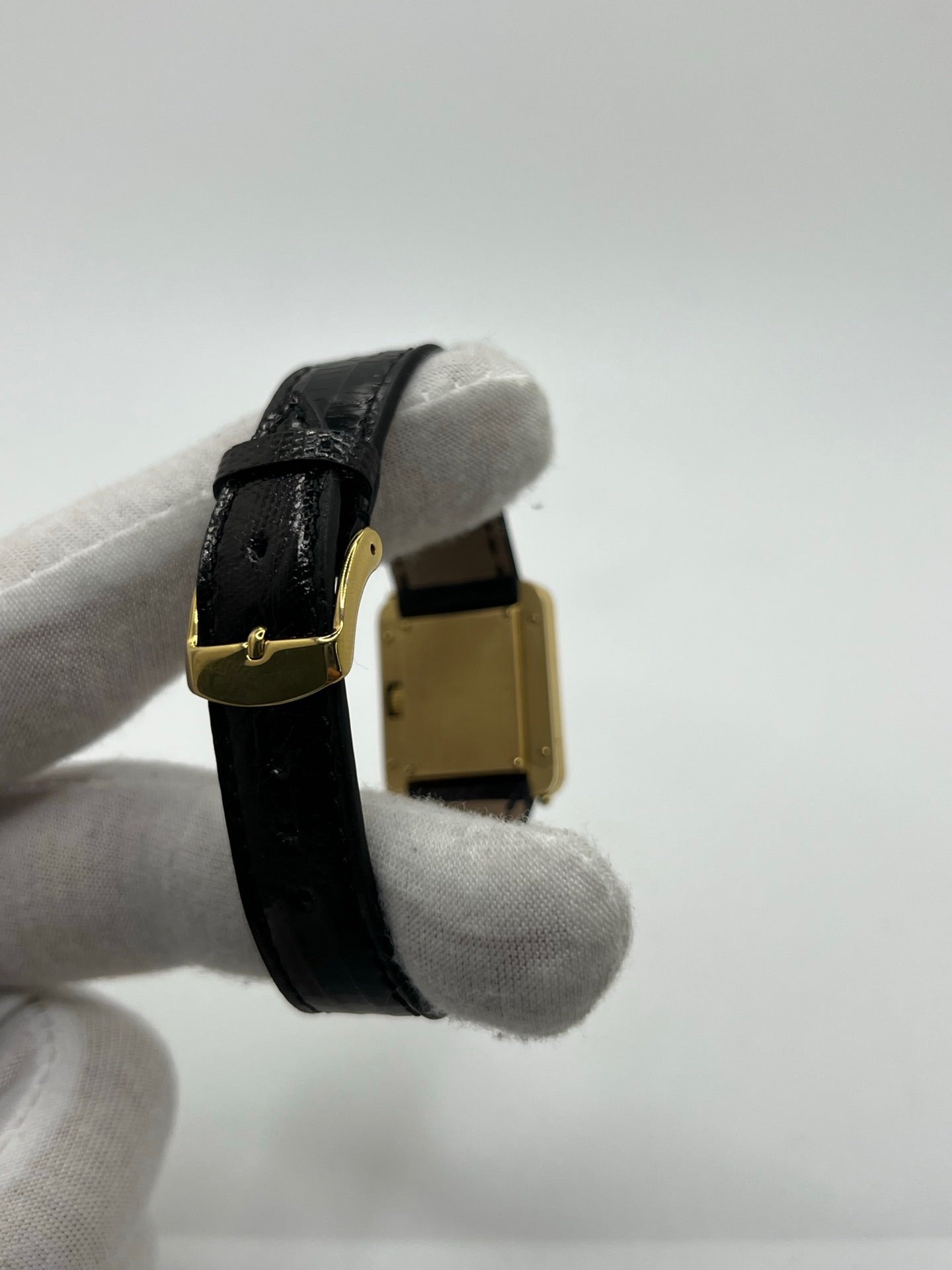 Montre femme Poiray Ma Première en or jaune 18K avec boîtier rectangulaire 22 x 26 mm, cadran doré sans chiffres et verre saphir. Modèle élégant équipé d’un mouvement quartz, bracelet en cuir noir et boucle en acier. Pièce d’occasion en très bon état présentant de légères traces d’usure non perceptibles. Montre raffinée, révisée récemment, idéale pour un style intemporel.
