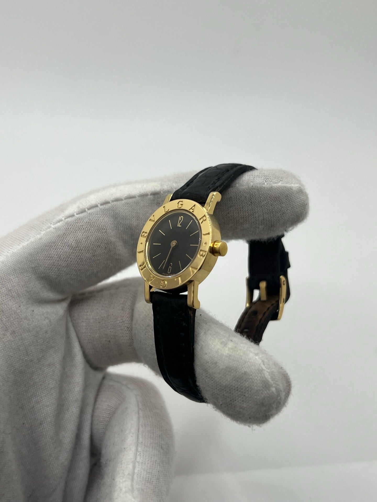 Montre femme Bulgari Bulgari Lady BB 23 GL en or jaune avec boîtier rond de 23 mm, cadran noir élégant et verre saphir. Cette montre de luxe à mouvement quartz est dotée d’un bracelet en cuir noir avec boucle ardillon en or jaune. Modèle emblématique au design intemporel, idéal pour un poignet féminin, alliant raffinement, précision et savoir-faire horloger italien. Parfaite comme montre habillée ou pièce de collection.