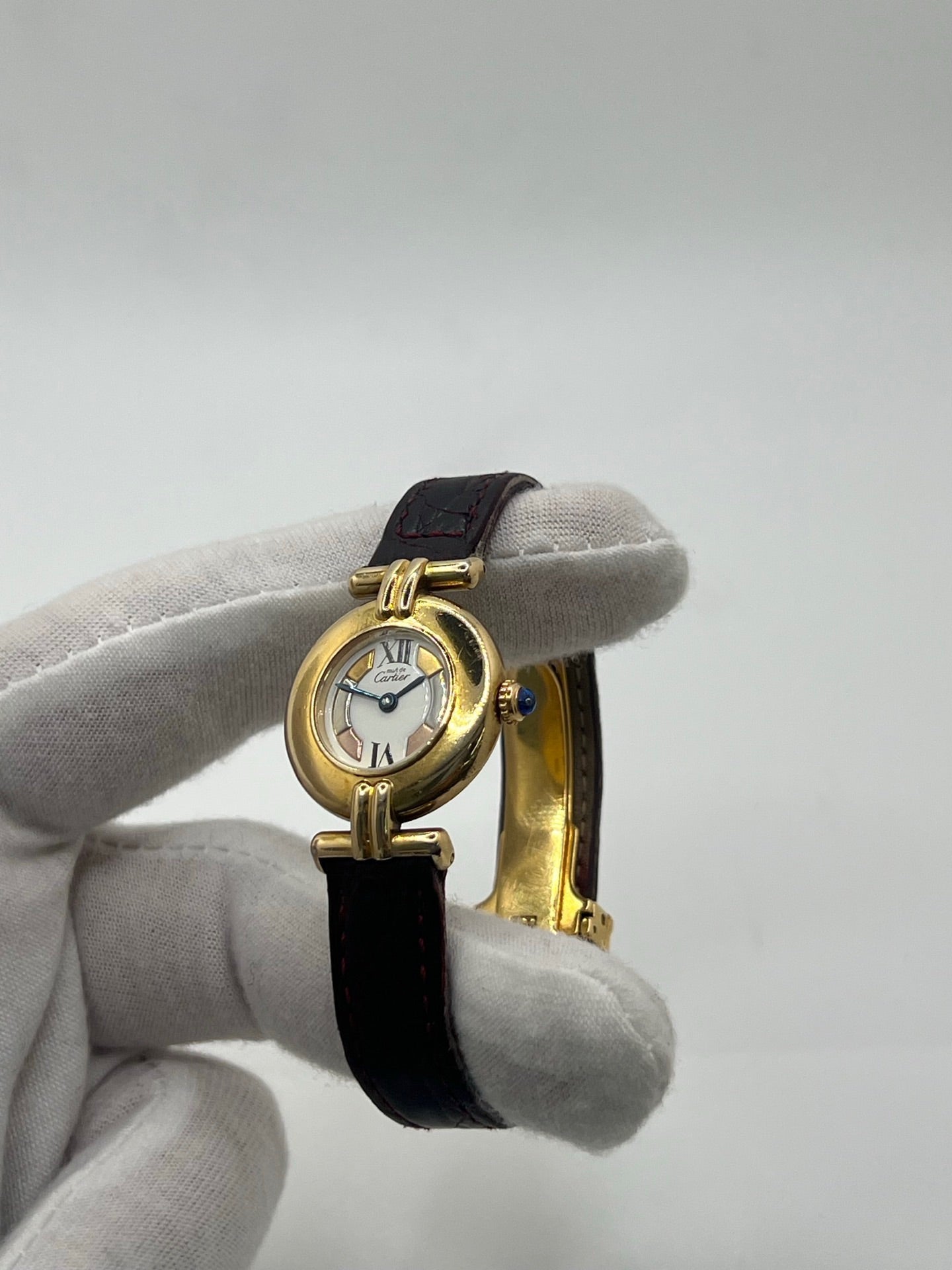 Montre femme Cartier Colisée réf. 590002 en argent avec mouvement quartz. Modèle vintage de 1995 au cadran blanc à chiffres romains et bracelet en cuir or. Verre saphir, boucle ardillon en argent. Élégance intemporelle signée Cartier, livrée avec coffret et papiers d’origine. Montre d’occasion en bon état, révisée en 2025.