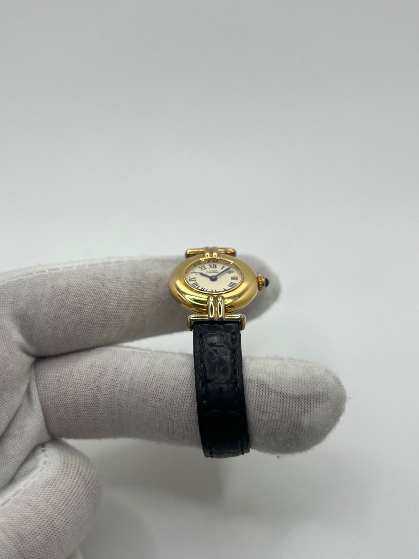 Montre Cartier Colisée Must Vermeil réf. 590002 pour femme, équipée d’un mouvement quartz précis. Boîtier en argent vermeil de 24 mm, cadran blanc à chiffres romains, verre saphir et bracelet en cuir noir avec boucle ardillon. Modèle d’occasion en bon état présentant quelques traces d’usure. Idéal pour les amateurs de montres élégantes et intemporelles.