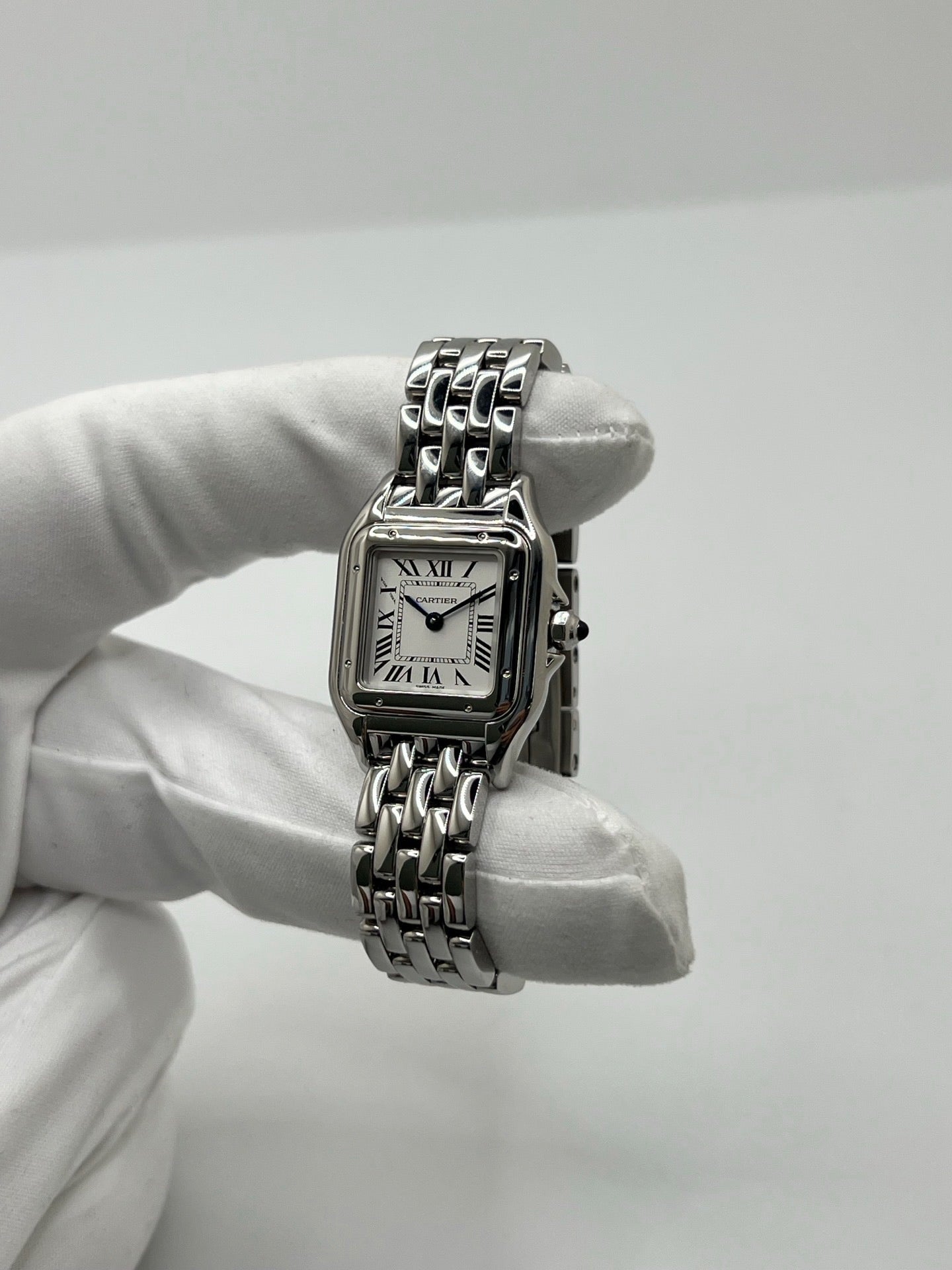 Montre Cartier Panthère femme en acier, référence WSPN0013, avec mouvement quartz. Boîtier rectangulaire 23 x 30 mm en acier, cadran argent à chiffres romains, verre saphir et bracelet acier avec boucle double plis. Modèle 2026 en état neuf, jamais porté, livré avec coffret et papiers d’origine. Élégante et intemporelle, cette montre Cartier Panthère allie raffinement, confort et design iconique.