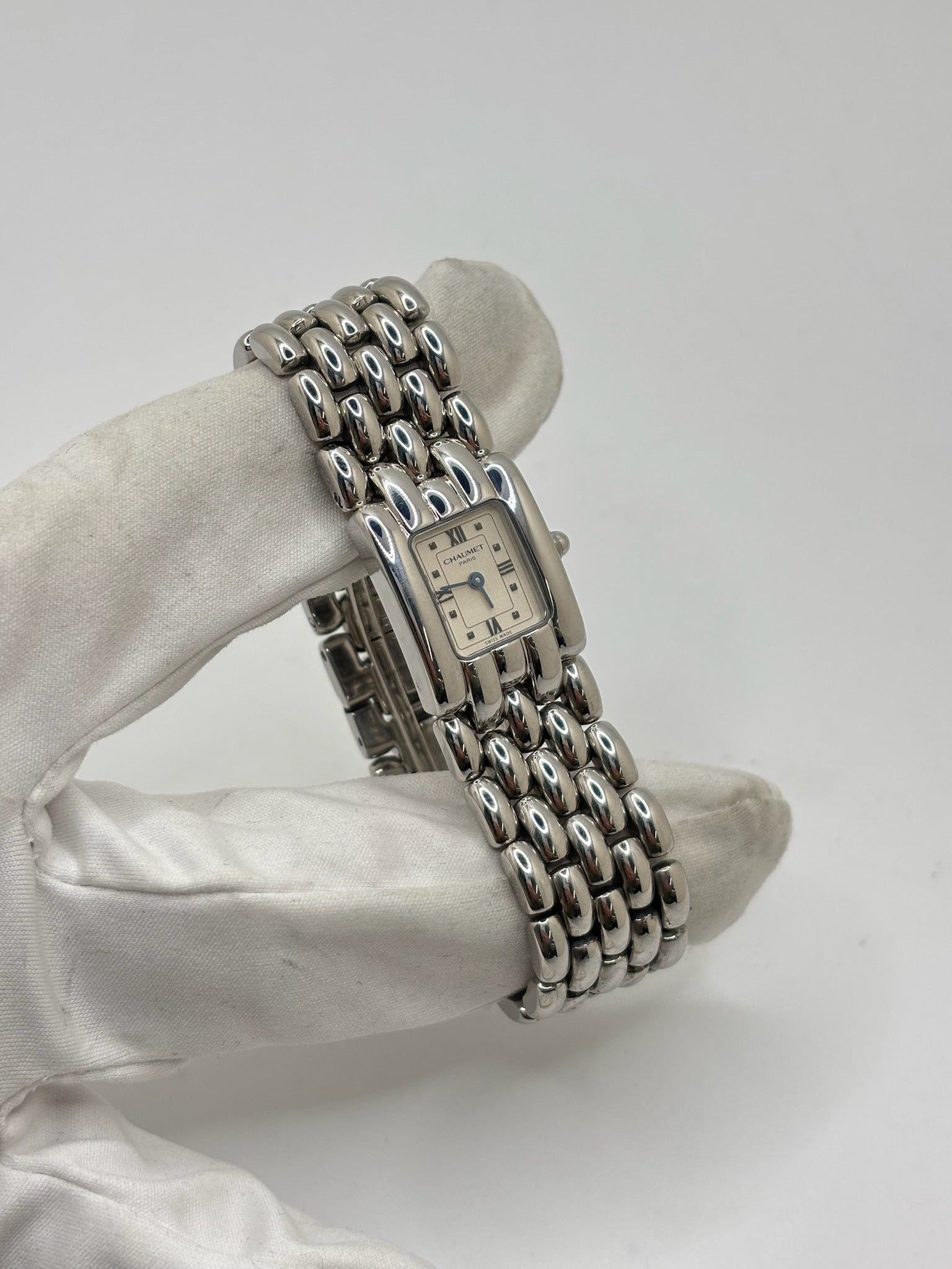 Montre Chaumet Khesis femme en acier avec mouvement quartz, cadran blanc à chiffres romains et verre saphir. Cette montre de luxe au design joaillier emblématique se distingue par son boîtier rectangulaire de 21 x 17 mm et son bracelet en acier intégré. Élégante et raffinée, cette Chaumet Khesis vintage de 1998 est accompagnée de ses papiers d’origine. Montre femme d’occasion en très bon état, idéale pour les collectionneuses et amatrices d’horlogerie de prestige.