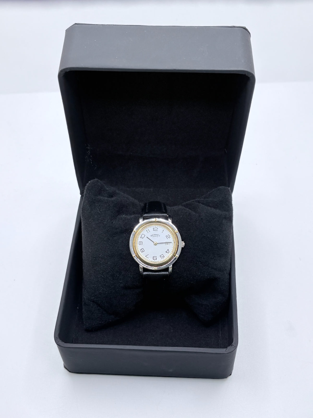 Montre Hermès Clipper pour femme en acier, équipée d’un mouvement à quartz. Son boîtier de 30 mm est associé à une lunette en or jaune, un cadran blanc avec chiffres arabes et un verre saphir. Cette montre Hermès Clipper est montée sur un bracelet en cuir de vache noir avec boucle ardillon en acier. Un modèle élégant et intemporel de la collection Clipper, idéal pour les amateurs de montres de luxe.