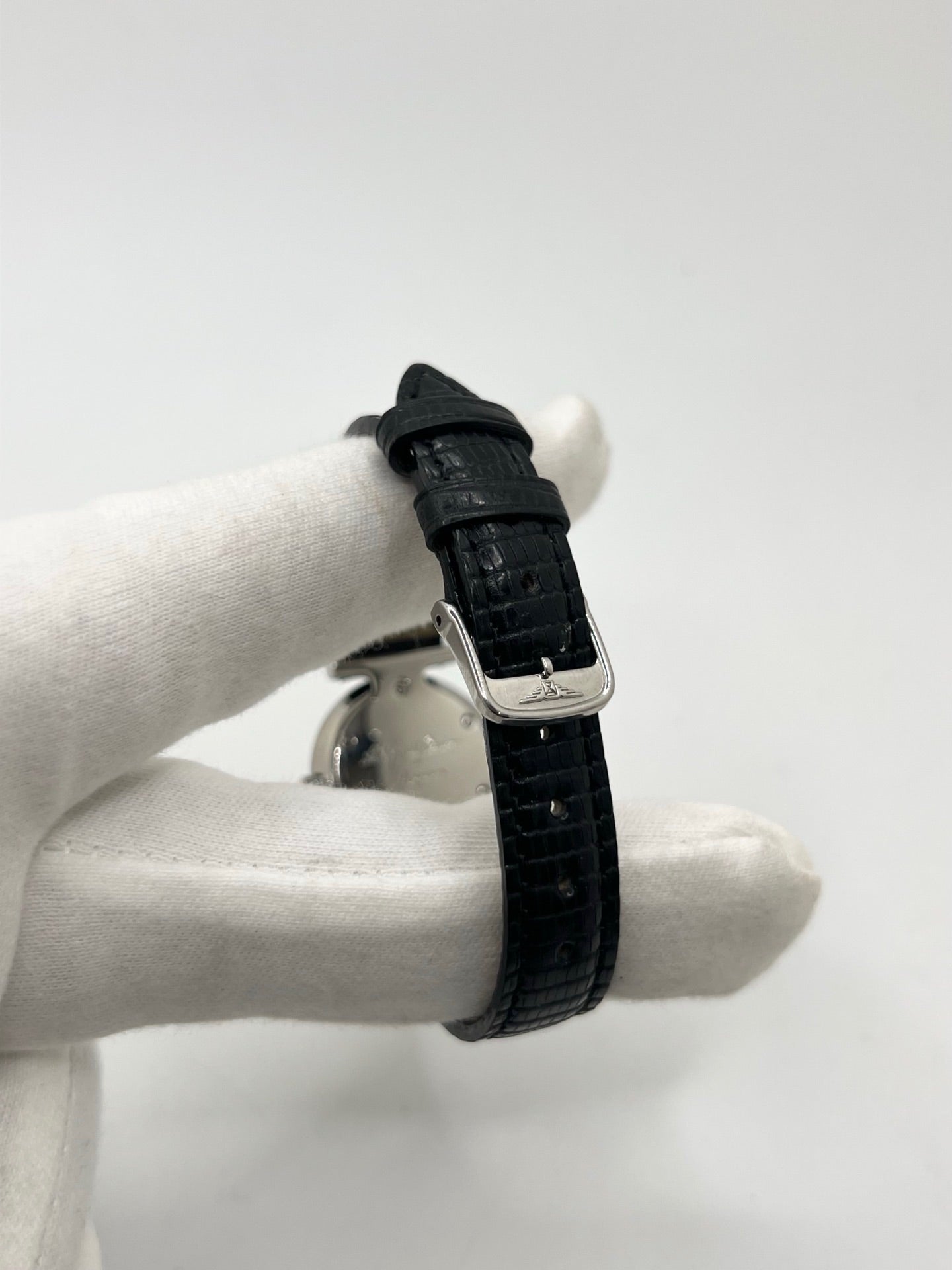 Montre Longines La Grande Classique L4.209.4 pour femme en acier avec bracelet en cuir de lézard noir. Ce modèle à mouvement quartz est doté d'un boîtier de 24 mm, d'un cadran blanc épuré sans chiffres, d'une lunette en acier et d'un verre saphir. Élégante et intemporelle, cette montre de luxe d'occasion est en très bon état avec de légères traces d'usure. Son design raffiné en fait un choix idéal pour un usage quotidien ou une collection horlogère.