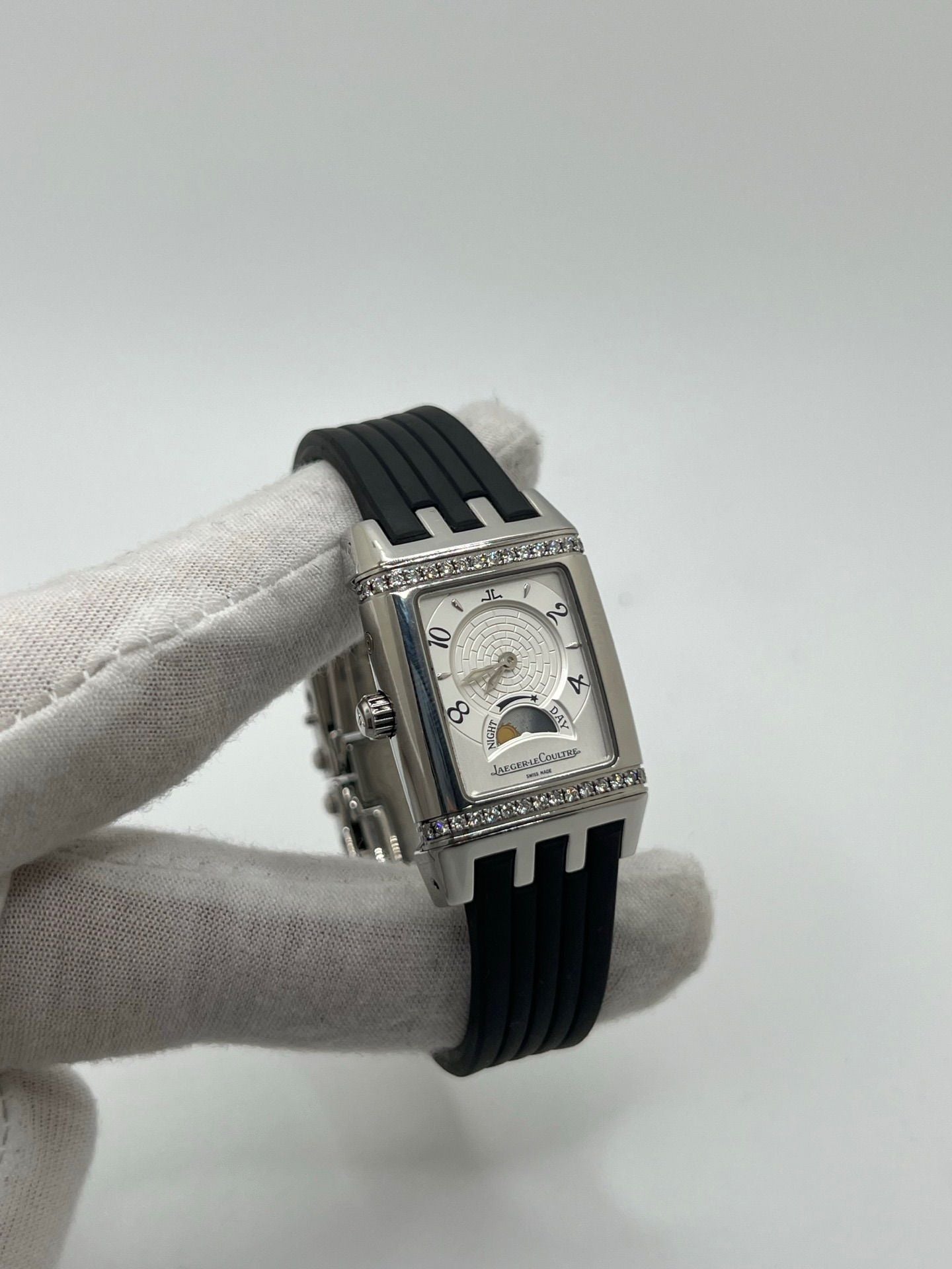 Montre Reverso Duetto référence 296.8.74 en acier, format rectangulaire, équipée d’un mouvement à remontage manuel. Modèle pour femme avec cadran blanc à chiffres arabes et verre saphir. Brace­let en caoutchouc noir avec boucle double plis. Pièce d’occasion en très bon état, présentant de légères traces d’usure discrètes.