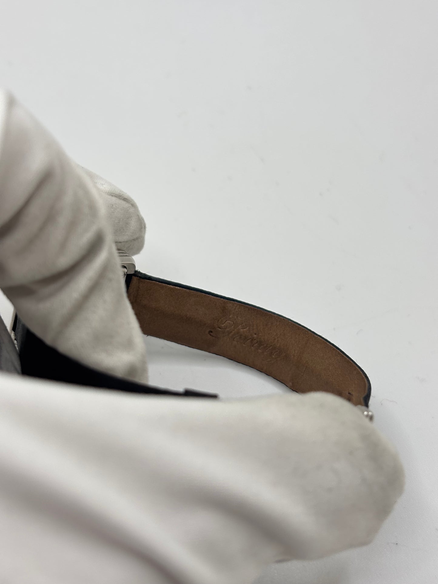 Montre Poiray Ma Première petit modèle en acier avec boîtier de 21,30 × 18,20 mm, cadran blanc épuré sans chiffres et verre minéral. Animée par un mouvement quartz, cette montre femme est équipée de son bracelet textile noir et de sa boucle ardillon d'origine en acier. Révisée, en excellent état et garantie 1 an, cette montre de luxe au style intemporel incarne l'élégance parisienne et le savoir-faire horloger de la maison Poiray.