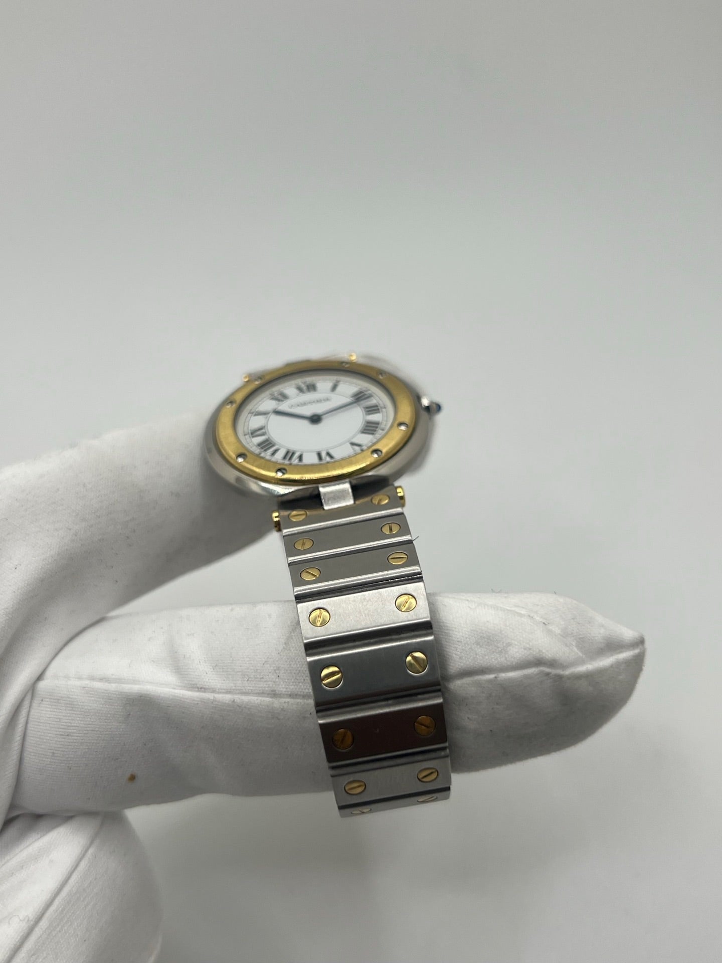 Montre Cartier Santos Ronde d'occasion en très bon état, boîtier or/acier de 33 mm avec lunette en or jaune et cadran blanc à chiffres romains. Mouvement quartz précis, verre saphir résistant aux rayures. Bracelet assorti or/acier avec boucle du même matériau. Livrée avec coffret d’origine, sans papiers. Parfaite pour collectionneurs ou amateurs de montres élégantes, disponible en stock à Paris, prix négociable