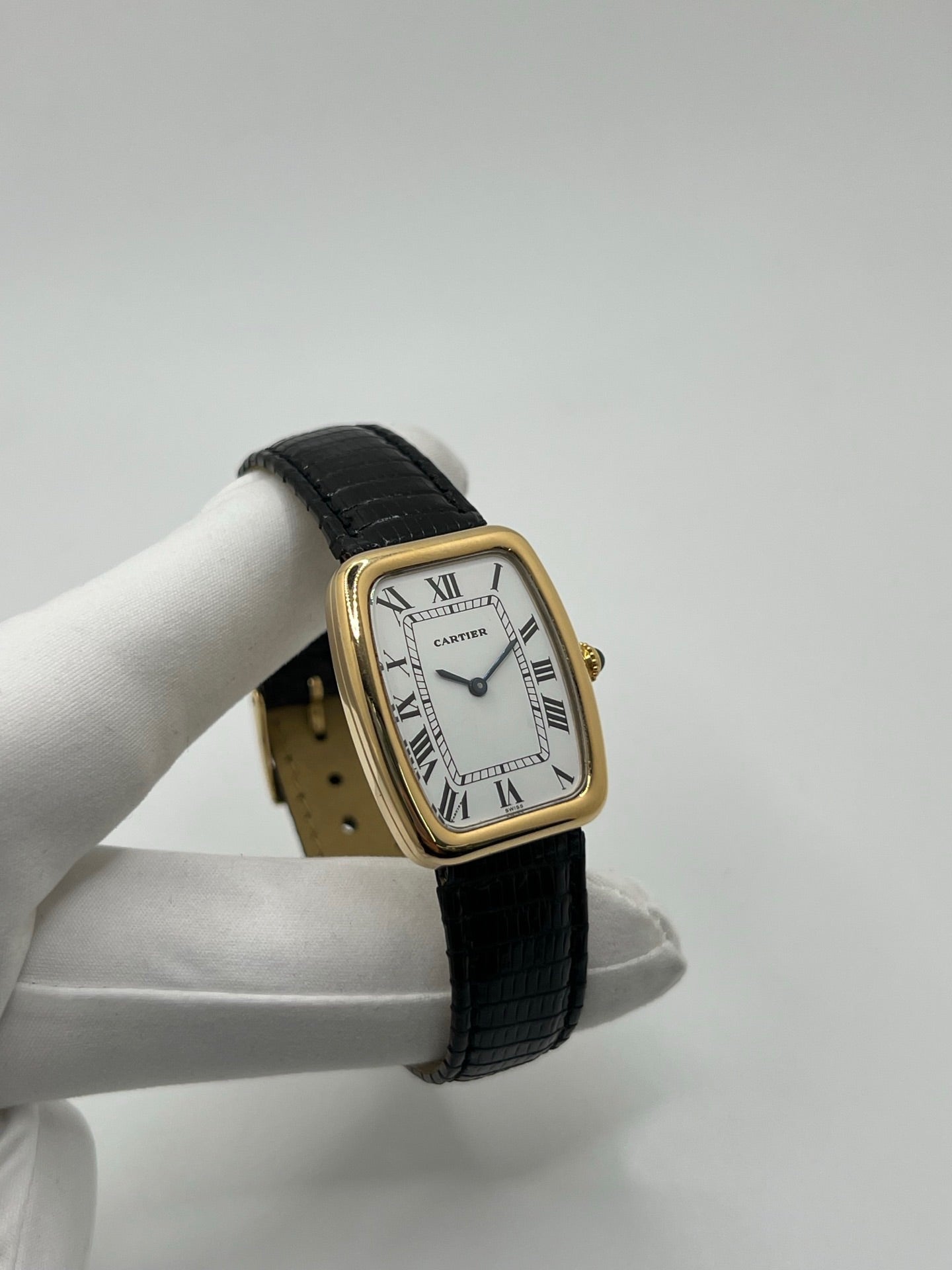 Montre Cartier Fabergé vintage en or jaune avec boîtier rectangulaire de 26 mm, cadran blanc à chiffres romains et bracelet en cuir noir. Ce modèle élégant à remontage manuel, fabriqué vers 1970, séduit par son style intemporel et raffiné. Montre homme ou unisexe d’occasion en très bon état, livrée avec coffret d’origine, idéale pour les amateurs d’horlogerie de luxe et de pièces vintage authentiques.