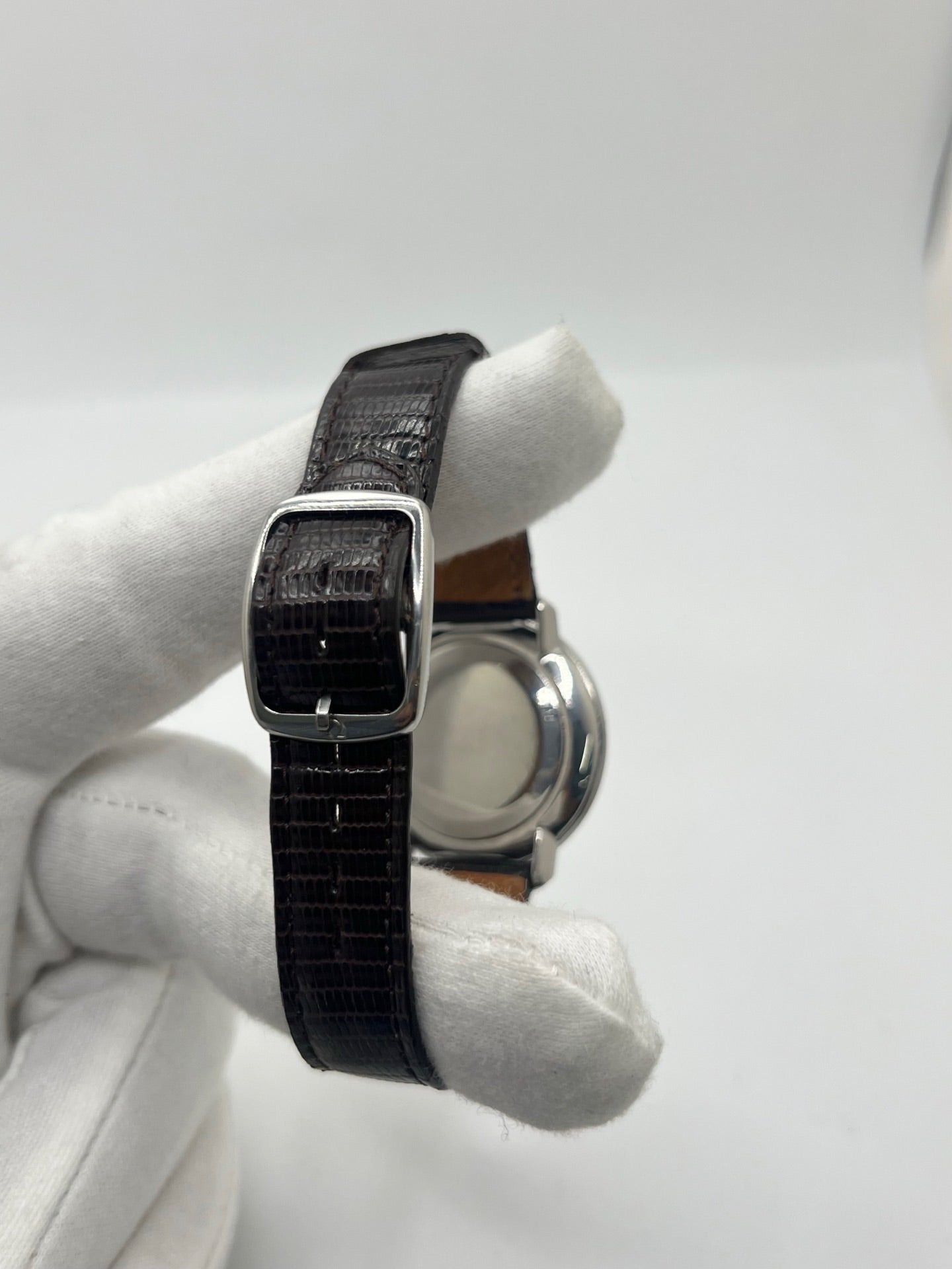 Montre Omega De Ville vintage référence 111.077 en acier, fabriquée en 1969. Ce modèle à remontage manuel est doté d'un cadran argent avec chiffres romains, d'un verre en plexiglas et d'un boîtier de 33 mm. Le bracelet en cuir noir avec boucle ardillon en acier complète son style classique et intemporel. Cette montre d'occasion révisée séduit les amateurs d'horlogerie vintage et de montres Omega de collection.
