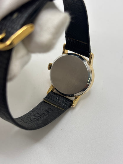 Montre Omega De Ville vintage référence 511.0508 pour femme, datant de 1967, avec boîtier en acier de 24 mm et cadran gris à index bâtons. Cette montre à remontage manuel est équipée du calibre Omega 625 à 17 rubis et est montée sur un bracelet en cuir noir avec boucle ardillon en acier. Révisée et en très bon état, elle présente de légères traces d'usure conformes à son âge. Une montre de collection au design élégant, idéale pour les amateurs d'horlogerie vintage.