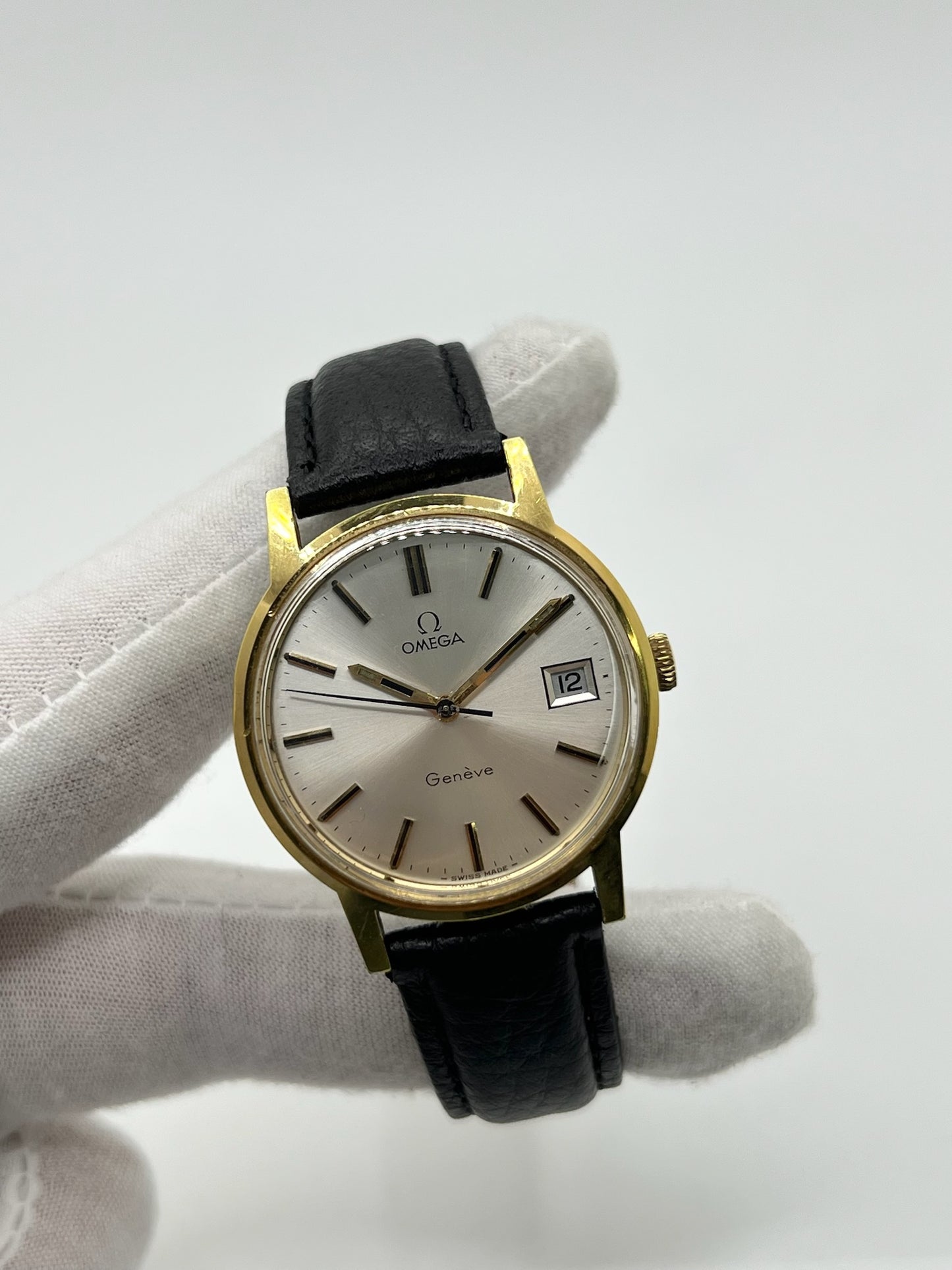 Montre Omega Genève vintage de 35 mm associant or et acier, au design classique et élégant. Cadran doré sobre offrant une lecture claire, complété par un affichage de la date. Boîtier équilibré et proportions harmonieuses, animé par un mouvement mécanique à remontage manuel révisé en interne. Bracelet en cuir noir apportant contraste et confort au poignet. Modèle en bon état d’usage, présentant des traces d’usure visibles telles que rayures, éraflures et petites marques liées à son âge et à son histoire.