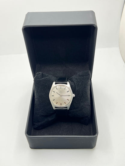 Montre Omega Genève 135.041 vintage de 1969, équipée d’un mouvement à remontage manuel avec calibre 601, offrant une réserve de marche de 48 heures. Son boîtier en acier de 34 mm est associé à un cadran argent à index bâtons, protégé par un verre Plexiglas. Cette Omega Genève est montée sur un bracelet noir en cuir de vache avec boucle ardillon en acier. En bon état, elle présente des traces d’usure visibles.
