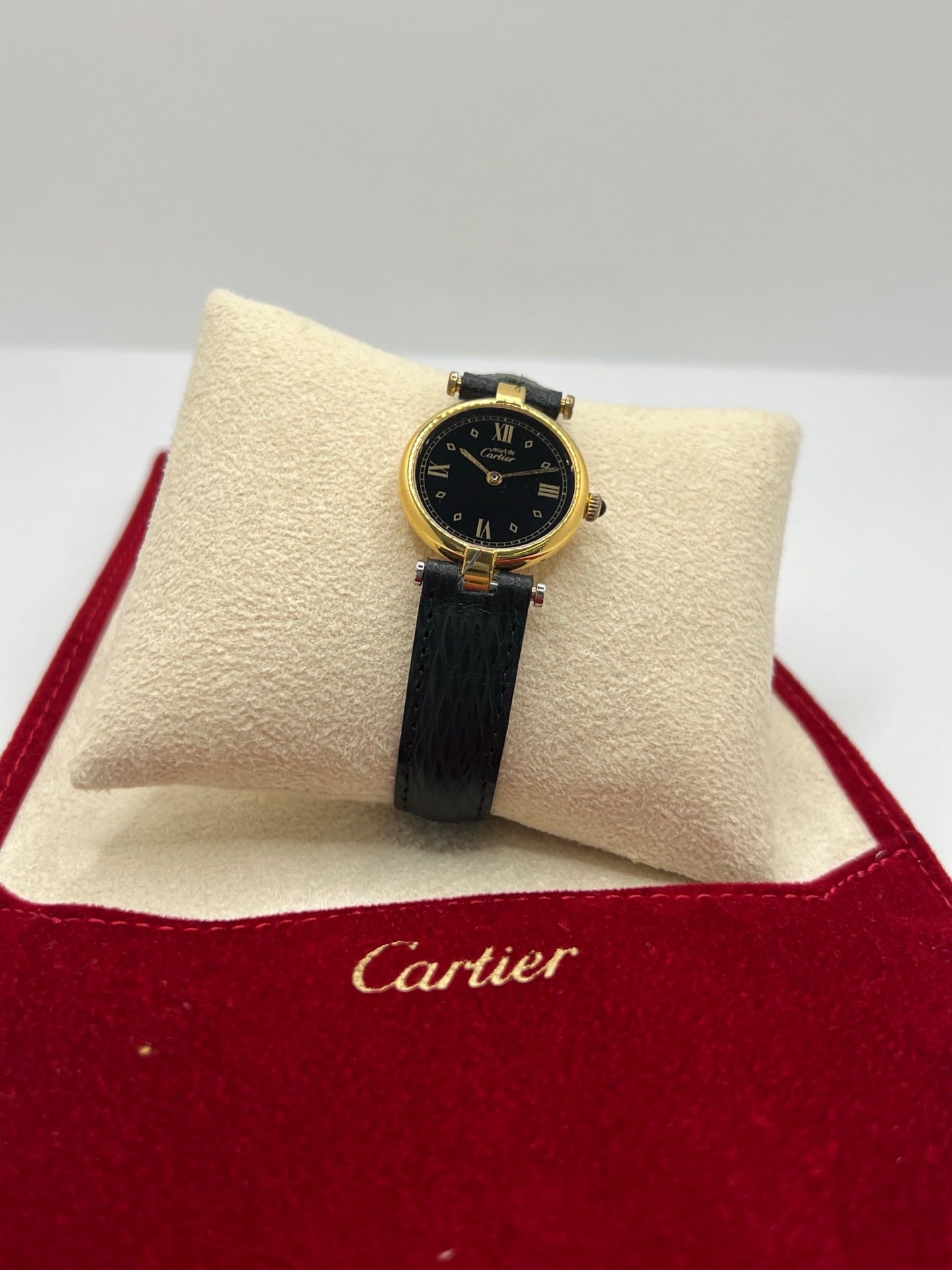 Cartier Must Vendôme référence 590004 en argent avec boîtier de 24 mm, cadran noir à chiffres romains et mouvement à quartz. Cette montre femme est équipée d'un bracelet en cuir, d'une boucle ardillon en acier et d'un verre saphir. Modèle d'occasion en très bon état, révisé en interne en 2026. Une montre Cartier vintage au design élégant, idéale pour les amateurs d'horlogerie de luxe et de pièces intemporelles.
