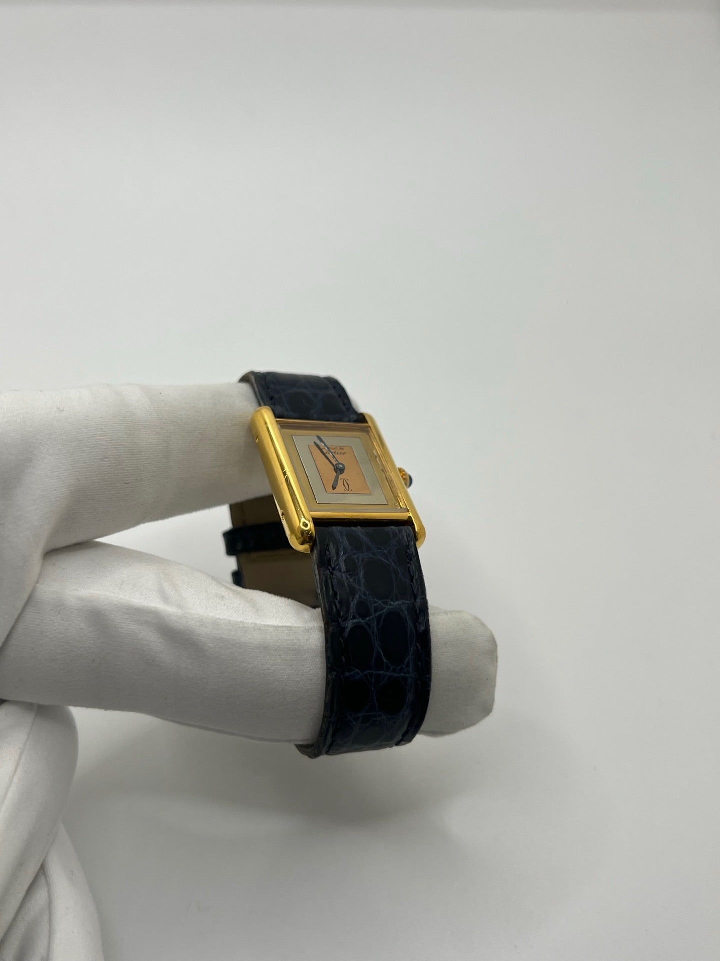 Montre Cartier Must de Cartier Tank Trinity en argent, à remontage manuel, avec boîtier de 23 x 30 mm et cadran jaune sans chiffres. Ce modèle emblématique est équipé d’un bracelet en cuir bleu avec boucle ardillon en acier, d’un verre minéral et d’une lunette en argent. Montre de luxe vintage homme ou unisexe, d’occasion en bon état, présentant des traces d’usure visibles. Révisée en interne, livrée avec coffret d’origine, idéale pour les collectionneurs de montres Cartier Tank Trinity.
