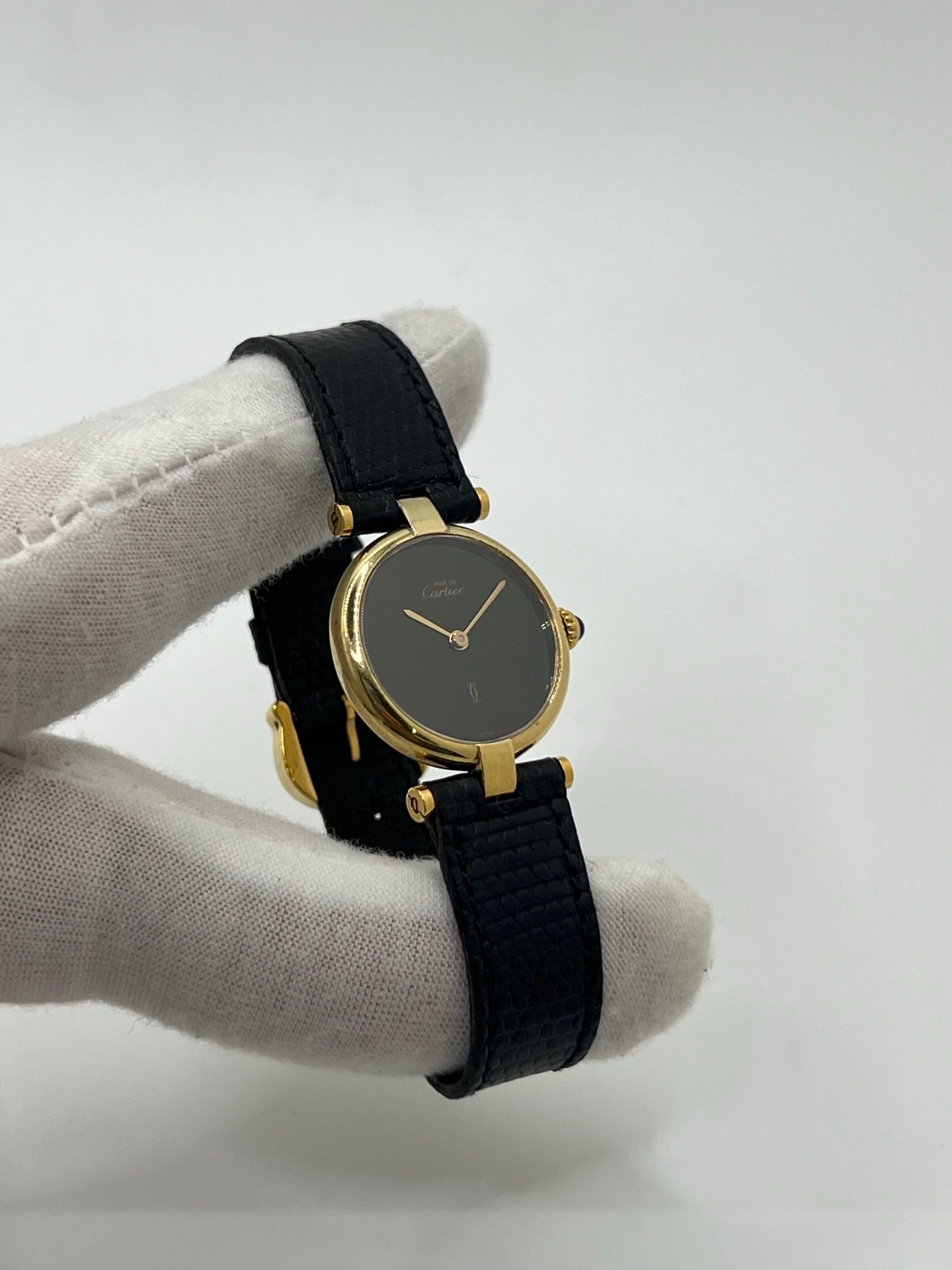 Montre Cartier Must de Cartier Vendome pour femme, boîtier argent de 24 mm avec cadran noir sans chiffres, mouvement quartz précis, verre saphir résistant aux rayures, bracelet cuir noir avec boucle ardillon en acier. État d’occasion très bon, livrée avec coffret d’origine. Élégante et intemporelle, idéale pour collection ou usage quotidien.