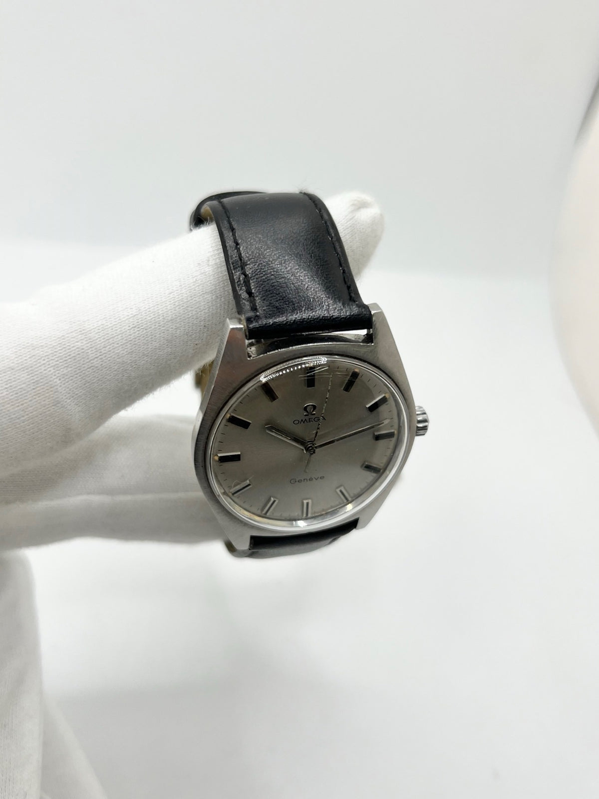Montre Omega Genève 135.041 vintage de 1969, équipée d’un mouvement à remontage manuel avec calibre 601, offrant une réserve de marche de 48 heures. Son boîtier en acier de 34 mm est associé à un cadran argent à index bâtons, protégé par un verre Plexiglas. Cette Omega Genève est montée sur un bracelet noir en cuir de vache avec boucle ardillon en acier. En bon état, elle présente des traces d’usure visibles.