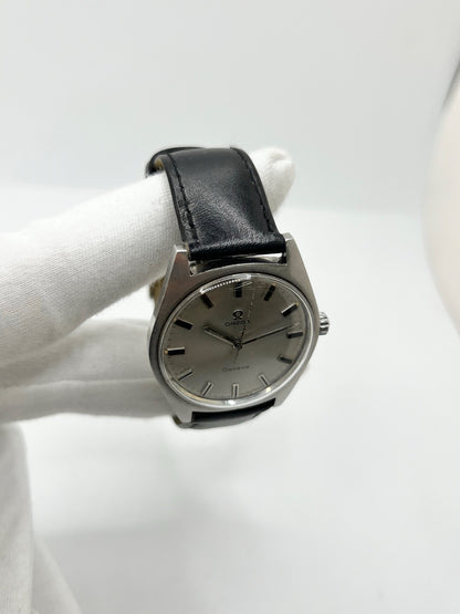 Montre Omega Genève 135.041 vintage de 1969, équipée d’un mouvement à remontage manuel avec calibre 601, offrant une réserve de marche de 48 heures. Son boîtier en acier de 34 mm est associé à un cadran argent à index bâtons, protégé par un verre Plexiglas. Cette Omega Genève est montée sur un bracelet noir en cuir de vache avec boucle ardillon en acier. En bon état, elle présente des traces d’usure visibles.