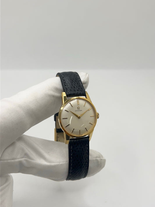 Montre femme Omega Classic vintage de 1961 en plaqué or, équipée d’un mouvement à remontage manuel. Boîtier de 25 mm avec cadran blanc à index bâtons sous verre plexiglas. Bracelet en cuir noir avec boucle ardillon en acier. Montre d’occasion en très bon état, présentant de légères micro-rayures non perceptibles au toucher. Révisée en avril 2026, sans coffret ni papiers d’origine, disponible en stock à Paris.
