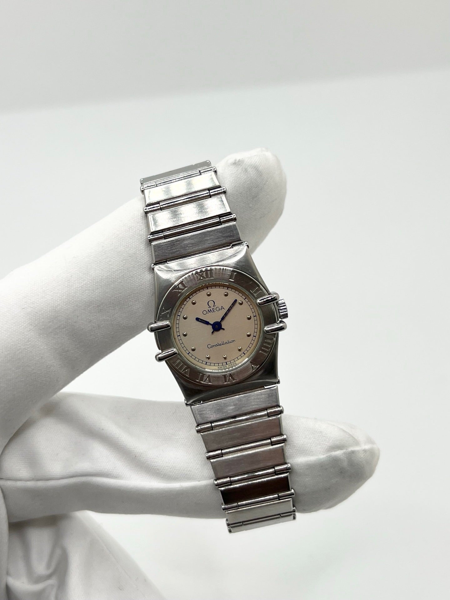 Montre Omega Constellation Quartz réf. 795.0876, modèle femme vintage en acier, mouvement quartz précis, boîtier et bracelet acier inoxydable, cadran argent massif sans chiffres, verre saphir. Dimensions 23 x 26 mm. Année 1985, état très bon avec légères traces d’usage peu visibles. Montre de luxe d’occasion, révisée en interne le 23 avril 2026. Sans boîte ni papiers d’origine, disponible à Paris. Pièce d’horlogerie suisse de collection Constellation.
