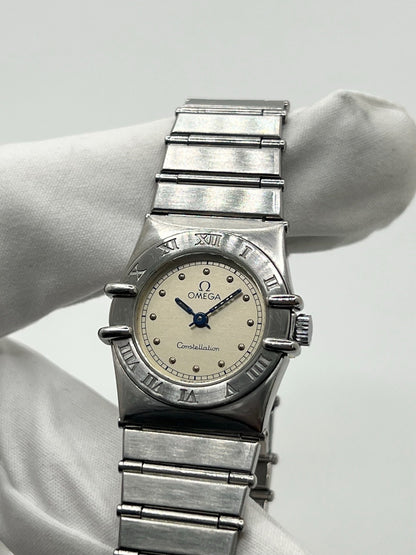 Montre Omega Constellation Quartz réf. 795.0876, modèle femme vintage en acier, mouvement quartz précis, boîtier et bracelet acier inoxydable, cadran argent massif sans chiffres, verre saphir. Dimensions 23 x 26 mm. Année 1985, état très bon avec légères traces d’usage peu visibles. Montre de luxe d’occasion, révisée en interne le 23 avril 2026. Sans boîte ni papiers d’origine, disponible à Paris. Pièce d’horlogerie suisse de collection Constellation.
