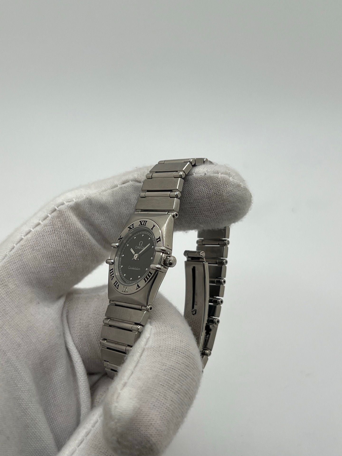 Montre femme Omega Constellation 795.1080 en acier avec cadran noir et chiffres romains. Mouvement quartz fiable, bracelet bicolore Or/Acier avec boucle pli. Diamètre 22 mm, verre saphir. État très bon, légère usure discrète. Coffret d’origine inclus, sans papiers. Parfaite pour élégance quotidienne et collection horlogère.