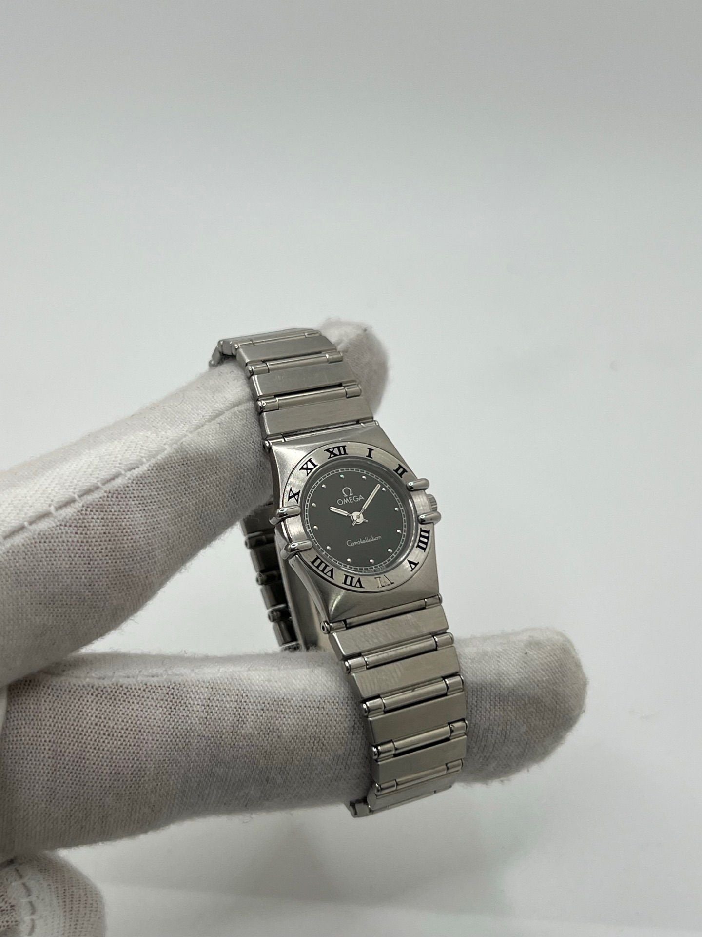 Montre femme Omega Constellation 795.1080 en acier avec cadran noir et chiffres romains. Mouvement quartz fiable, bracelet bicolore Or/Acier avec boucle pli. Diamètre 22 mm, verre saphir. État très bon, légère usure discrète. Coffret d’origine inclus, sans papiers. Parfaite pour élégance quotidienne et collection horlogère.