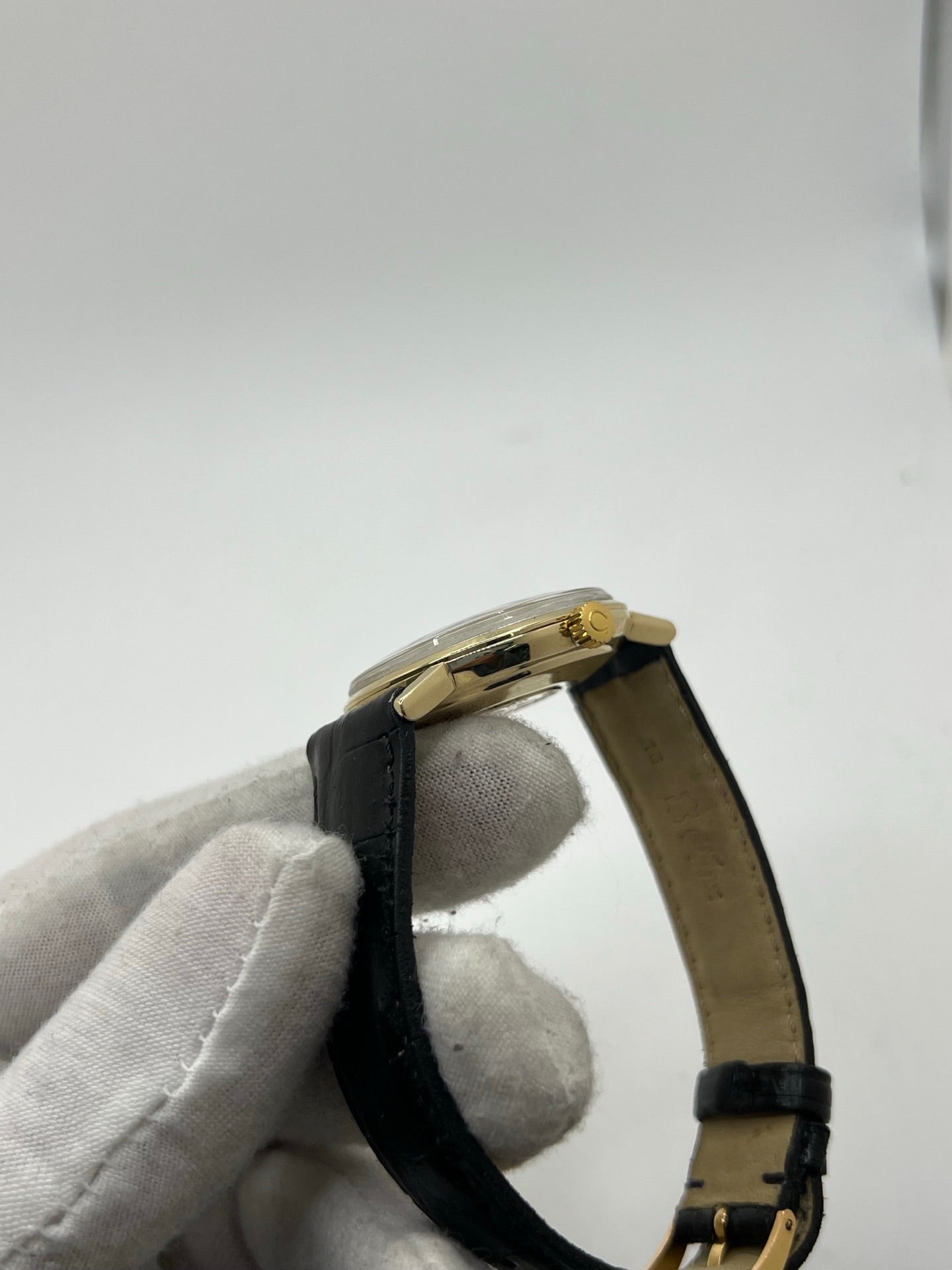 Montre Omega Seamaster DeVille vintage de 1961 en or jaune 14 carats, équipée d’un mouvement automatique calibre 560. Boîtier rond de 34 mm avec verre plexiglas, cadran champagne à index bâtons et date. Bracelet en cuir de crocodile noir avec boucle en or. Montre homme élégante et intemporelle, en bon état avec traces d’usure, récemment révisée, idéale pour collection ou usage quotidien.