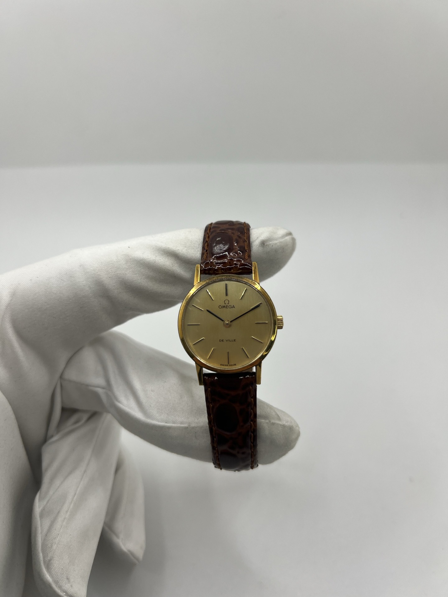 Montre Omega De Ville 511.0392 vintage de 1973 en acier plaqué or avec cadran doré et bracelet cuir brun. Cette Omega Seamaster De Ville mécanique de 24 mm est équipée du calibre Omega 625 à remontage manuel, apprécié pour son charme horloger authentique. Élégante et raffinée, cette Omega vintage femme séduit par son style intemporel inspiré des années 70. Montre révisée avec boucle Omega d’origine, boîte Omega et certificat d’authenticité.