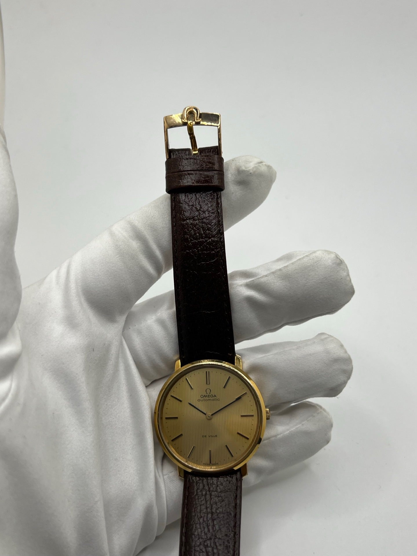 Montre Omega De Ville référence 151.0039 vintage de 1973 en acier avec mouvement automatique calibre 711, cadran doré et bracelet en cuir noir. Ce modèle homme ou unisexe de 35,5 mm présente un design élégant et intemporel. Montre d’occasion en très bon état, révisée en interne le 13 mars 2026, avec légères traces d’usure discrètes. Pièce classique de collection sans coffret ni papiers d’origine.