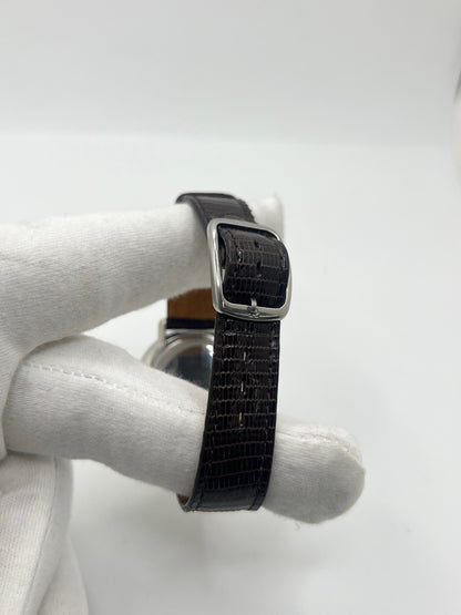 Montre Omega De Ville vintage référence 111.077 en acier, fabriquée en 1969. Ce modèle à remontage manuel est doté d'un cadran argent avec chiffres romains, d'un verre en plexiglas et d'un boîtier de 33 mm. Le bracelet en cuir noir avec boucle ardillon en acier complète son style classique et intemporel. Cette montre d'occasion révisée séduit les amateurs d'horlogerie vintage et de montres Omega de collection.
